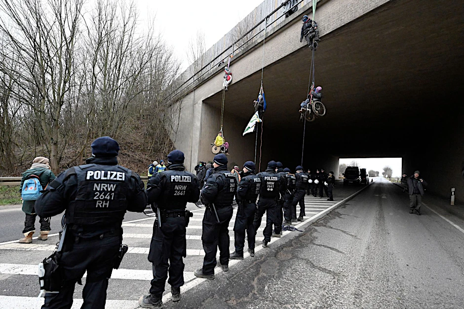 Klimaaktivisten in Rollstühlen haben sich von einer Autobahnbrücke der A44 in der Nähe von Lützerath abgeseilt. Die Brücke liegt ungefähr vier Kilometer Luftlinie vom Braunkohleort Lützerath entfernt.&nbsp;