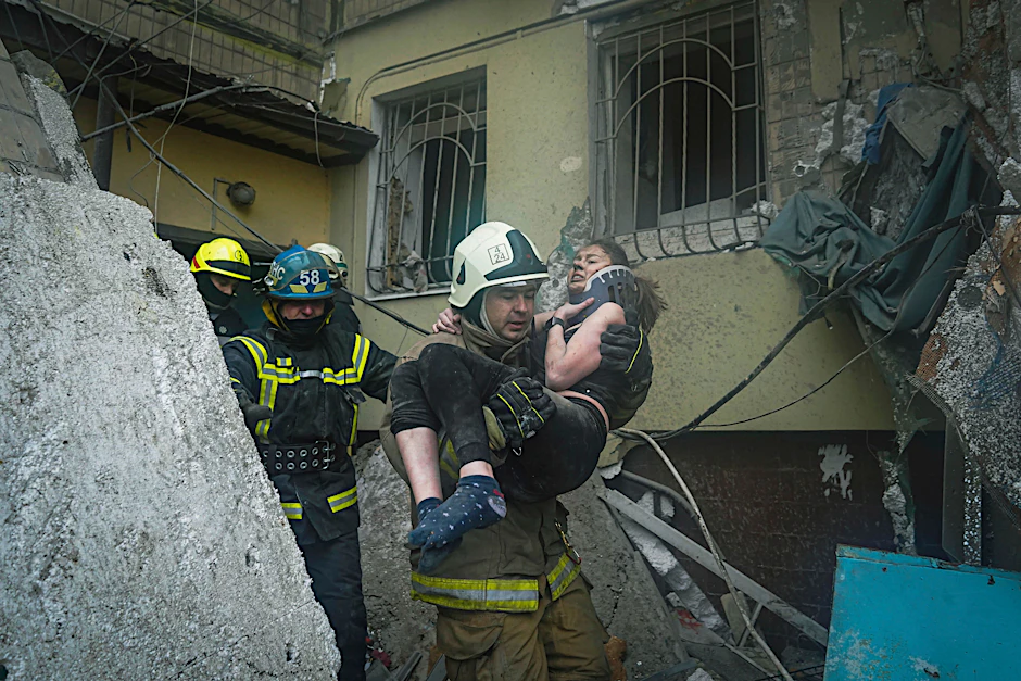 Feuerwehrleute bergen eine junge Frau aus den Trümmern des Wohnhauses in Dnipro.