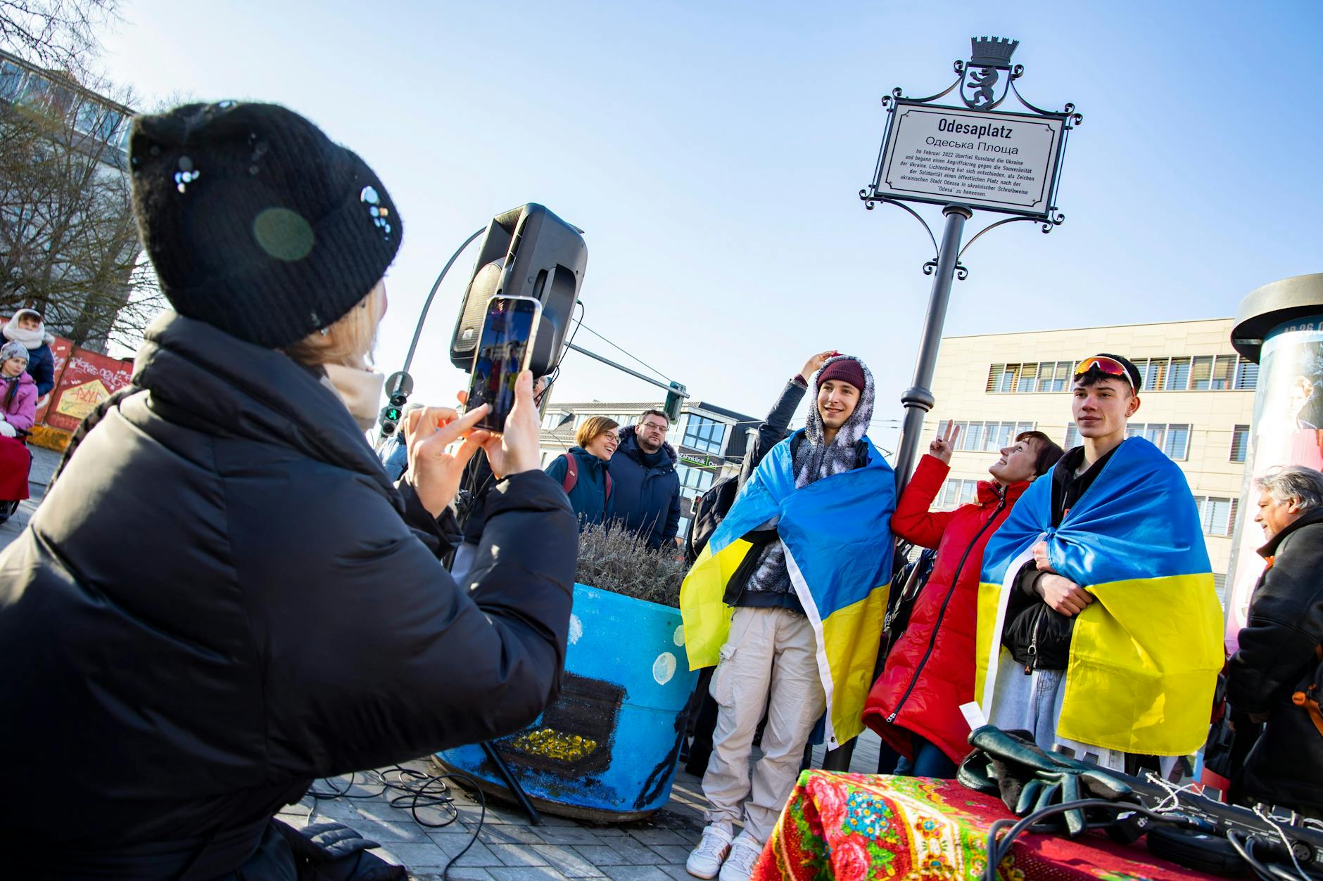 Die 18-Jährigen Evgenii aus Charkiw (l.) und Dmytro aus Kirovograd (r.) posieren nach der Enthüllungszeremonie am Odesaplatz mit Natalja Toporynska (M.), der Lehrerin ihrer Willkommensklasse am Marzahner Viktor-Klemperer-Kolleg.
