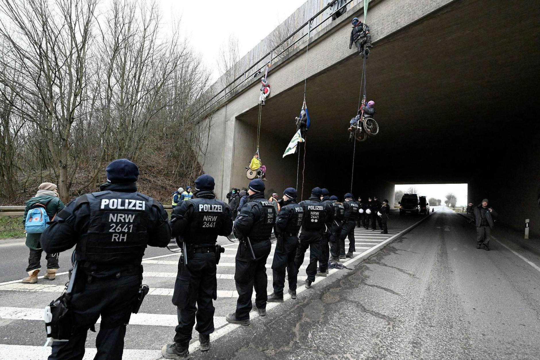 Klimaaktivisten in Rollstühlen haben sich von einer Autobahnbrücke der A44 in der Nähe von Lützerath abgeseilt. Die Brücke liegt ungefähr vier Kilometer Luftlinie vom Braunkohleort entfernt.
