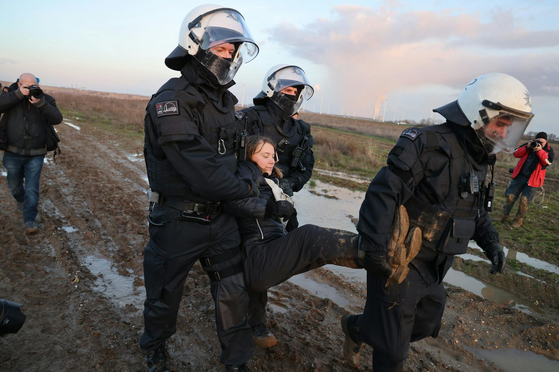 Polizisten tragen die schwedische Klimaaktivistin Greta Thunberg aus einer Gruppe von Demonstranten und Aktivisten heraus und vom Rand des Braunkohletagebaus Garzweiler II weg. 