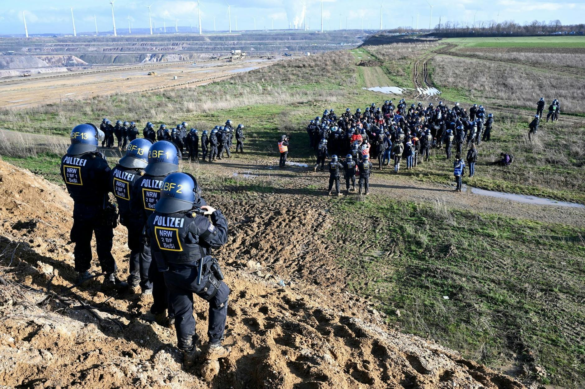 Gepanzerte Polizisten kesseln Klima-Aktivisten ein am Tagebau Garzweiler ein.