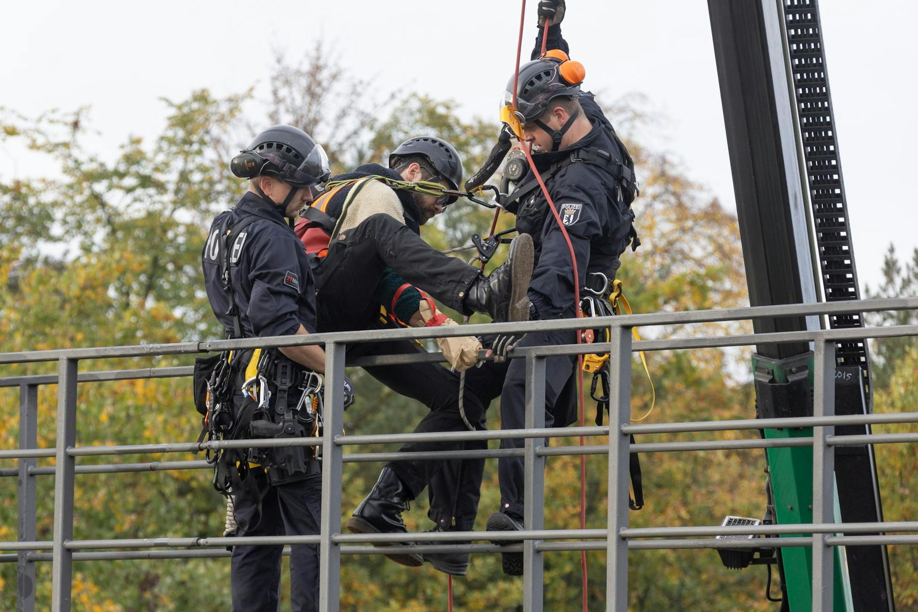 Klima-Kleber auf der A100: Polizisten holen zwei Aktivisten von einer Schilderbrücke.