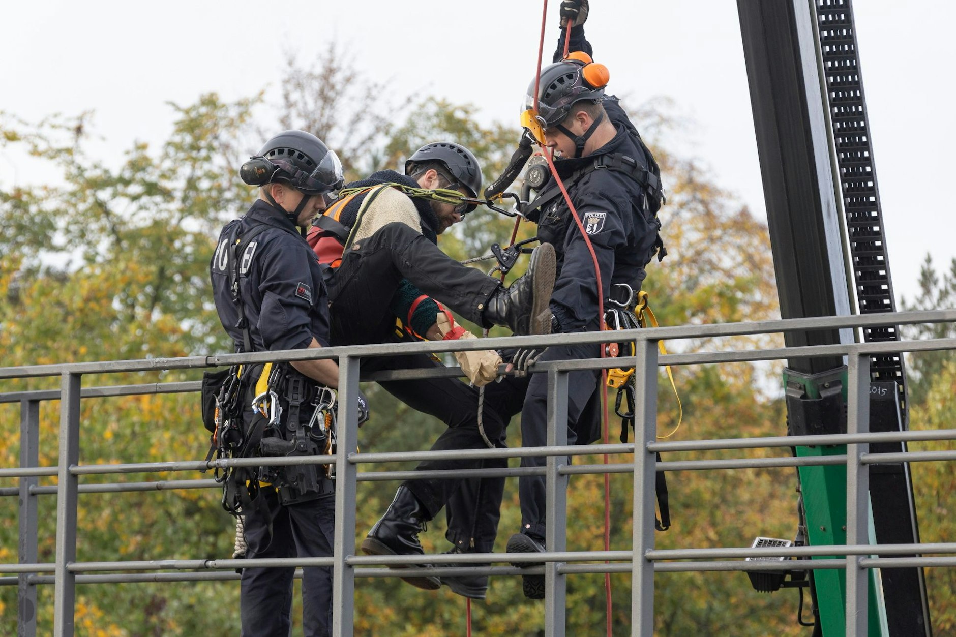 Klima-Kleber auf der A100: Polizisten holen zwei Aktivisten von einer Schilderbrücke.