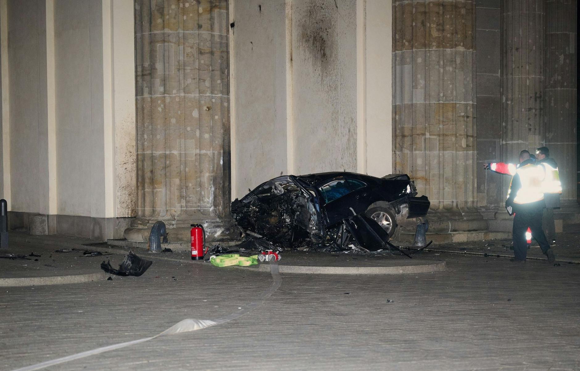ARCHIV - Ein zerstörter PKW liegt zwischen zwei Säulen des Brandenburger Tors.