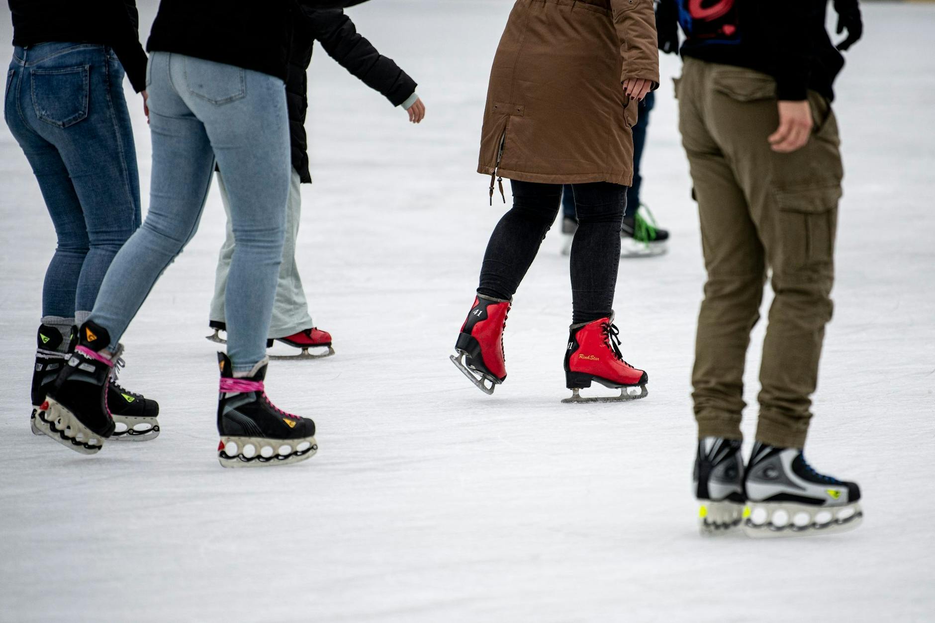 ARCHIV - Besucher laufen auf der Eisfläche.