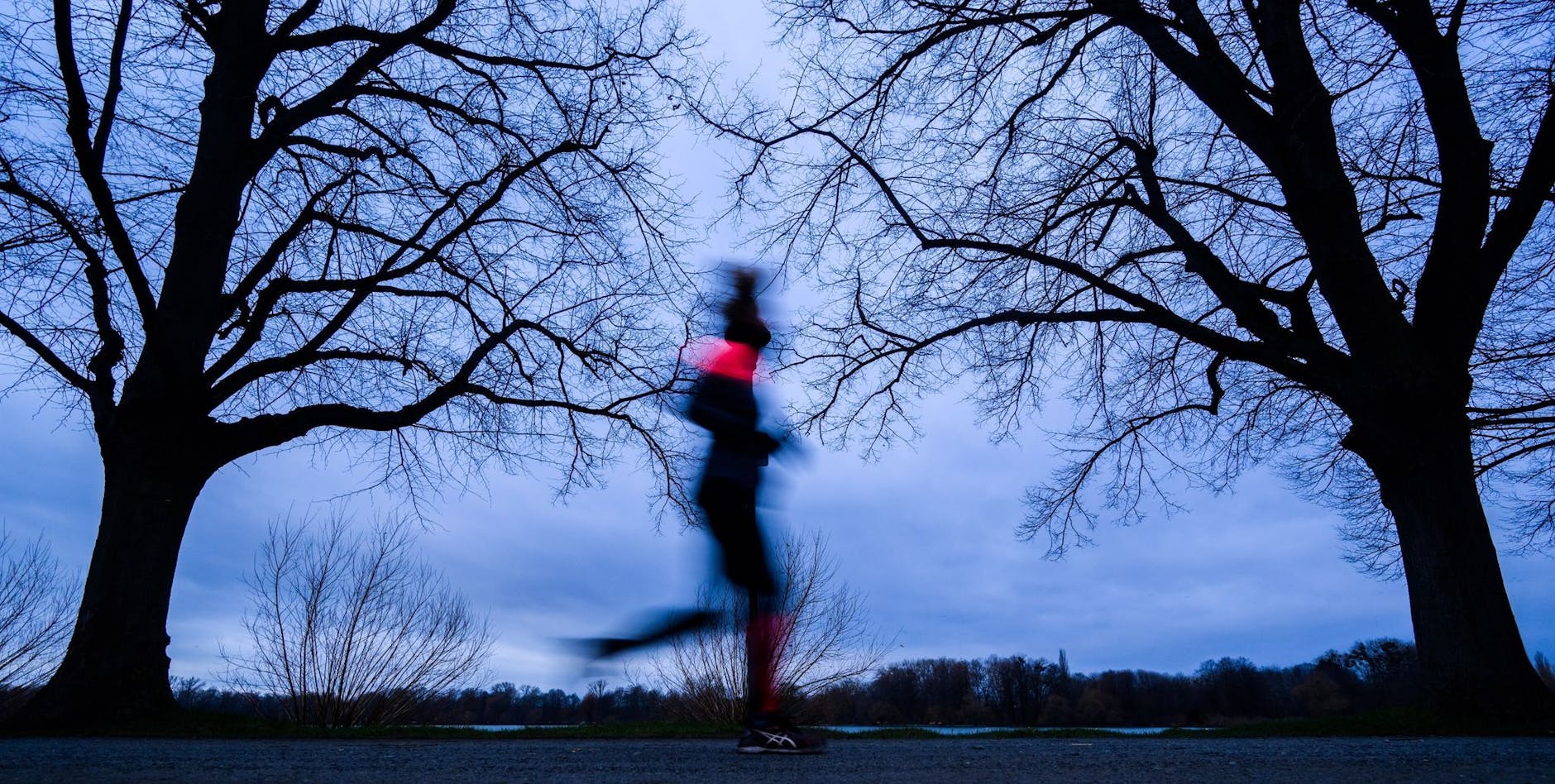 Eine Joggerin läuft am Maschsee in Hannover entlang.