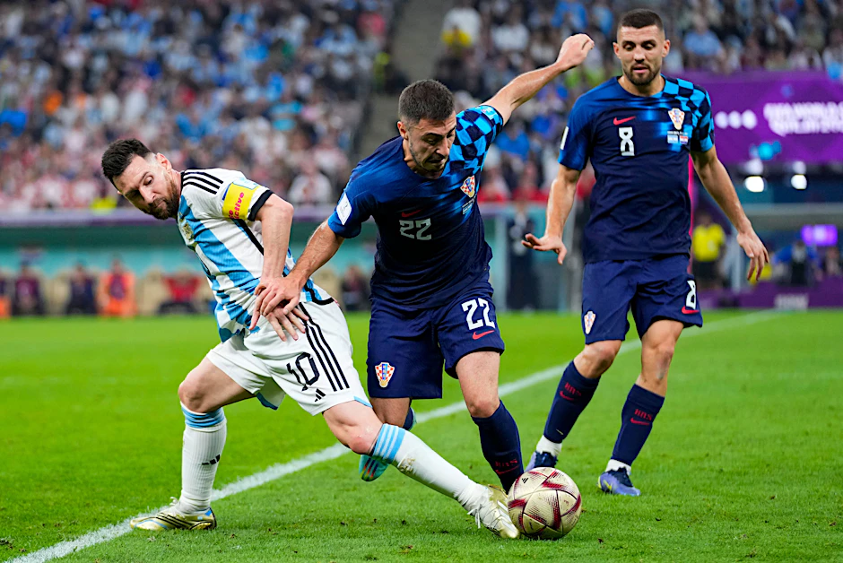 Josip Juranovic (M.) während des WM-Halbfinals im Duell mit Argentiniens Superstar Lionel Messi (l.).