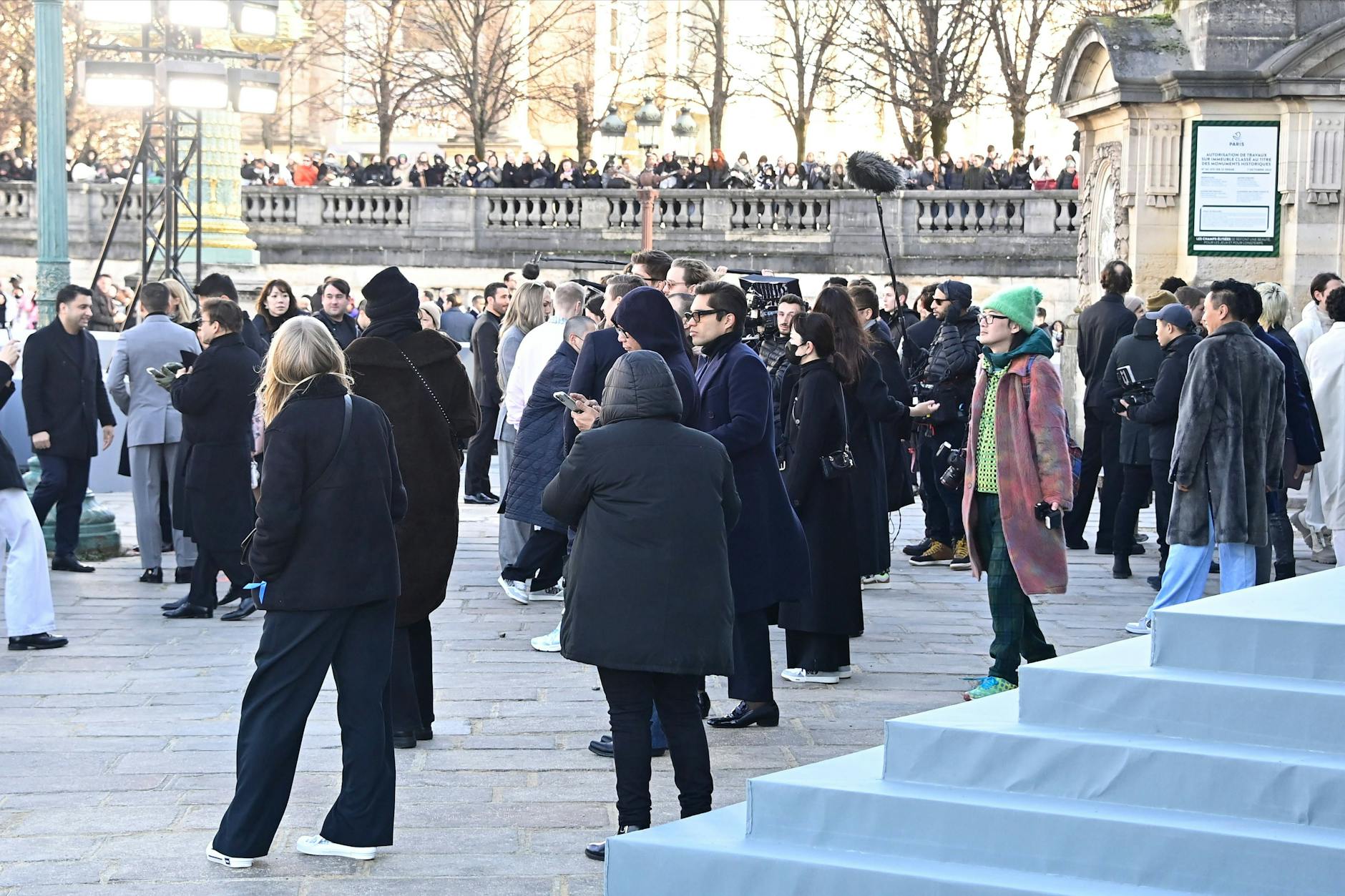 Zuschauer und Gäste warteten auf dem Place de la Concorde vor dem Eingang eines großen weißen Kubus, in dem die Dior-Show stattfand.