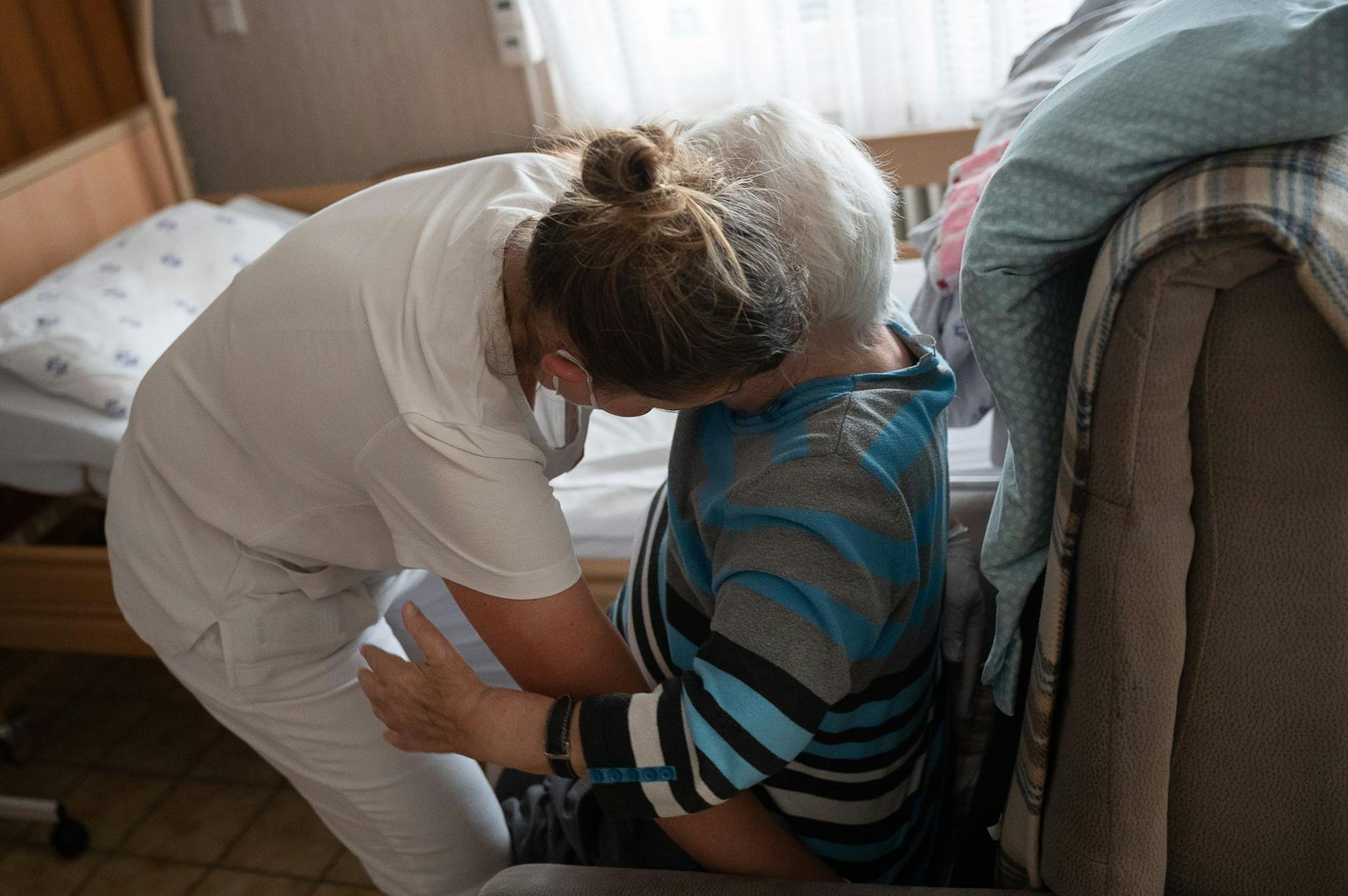 ARCHIV - Eine Pflegefachkraft hilft in der ambulanten Pflege einer Frau beim Aufstehen.