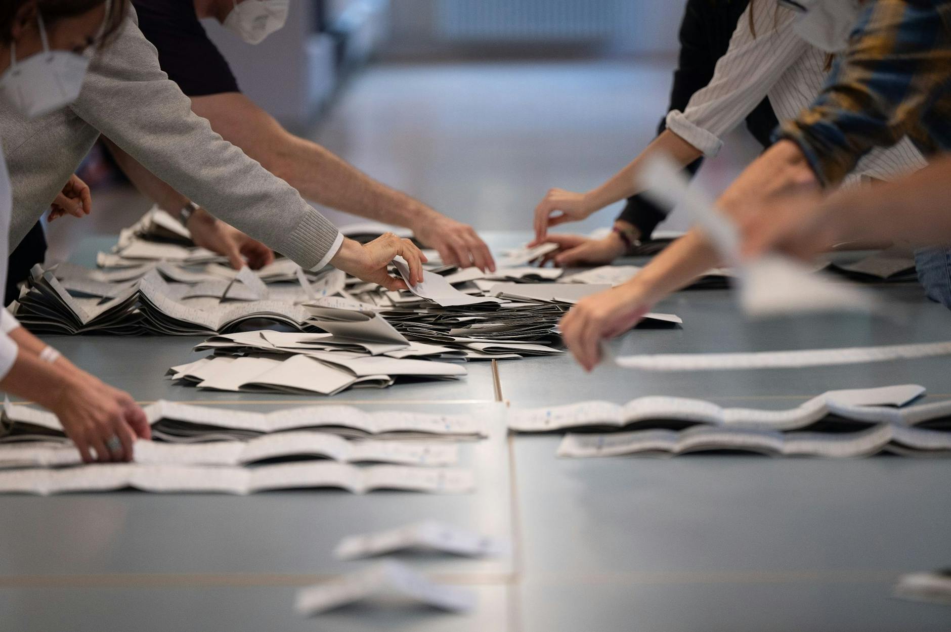 ARCHIV - Wahlhelfer und Wahlhelferinnen zählen in einem Wahllokal Stimmzettel für die Bundestagswahl.