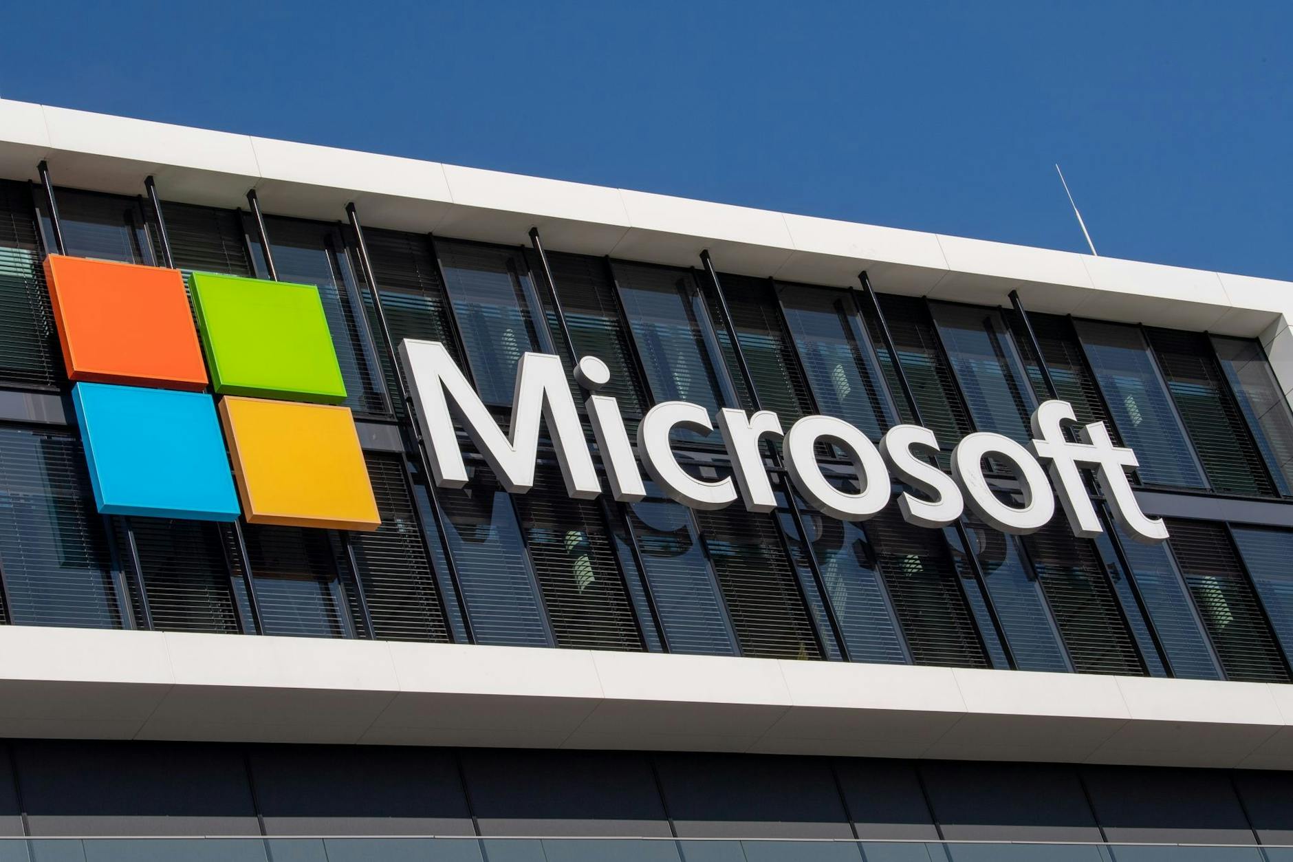 ARCHIV - Das Microsoft-Logo hängt an der Fassade eines Bürogebäudes in München: Microsoft will Jobs abbauen.