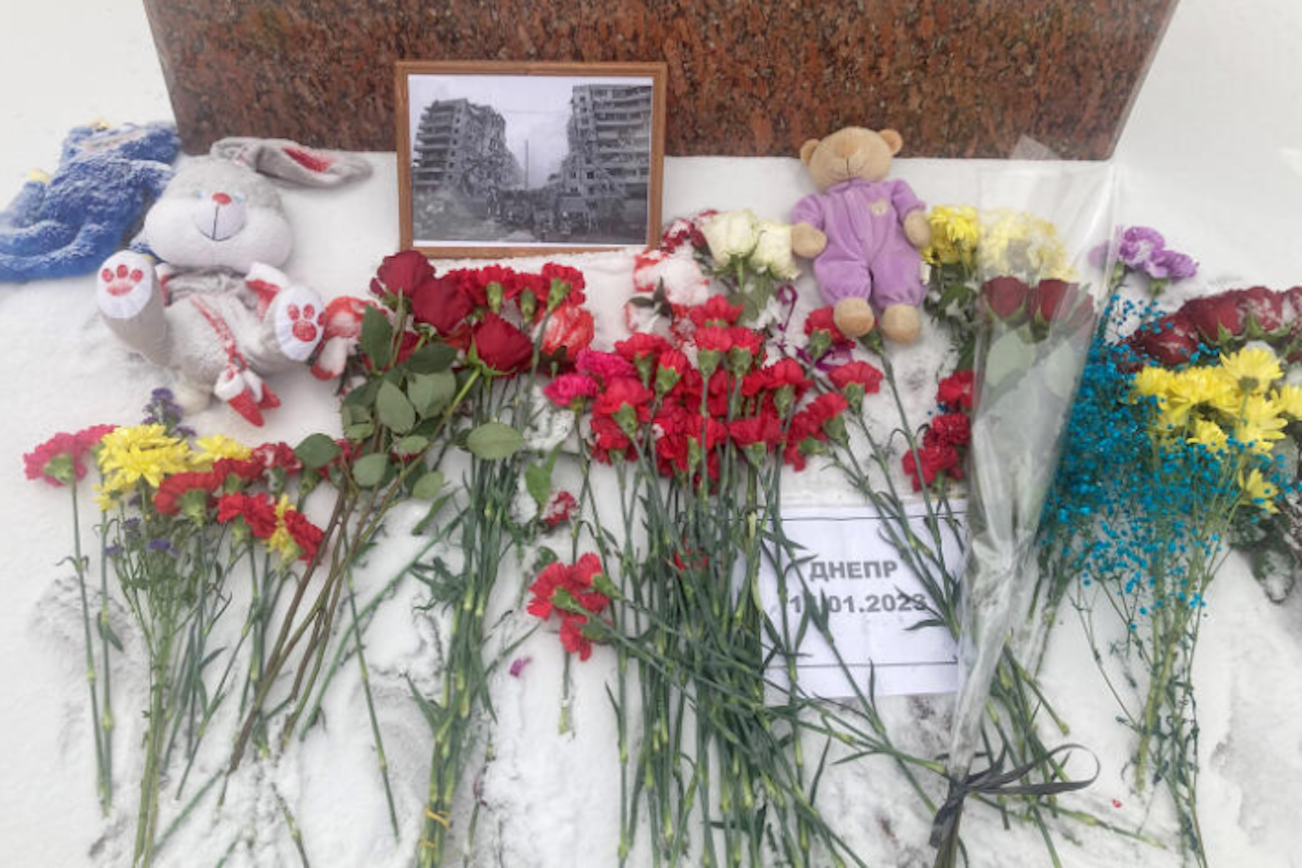 Nach dem russischen Angriff auf Dnipro haben Menschen in Moskau Blumen und ein gerahmtes Foto des zerstörten Wohnhauses abgelegt.