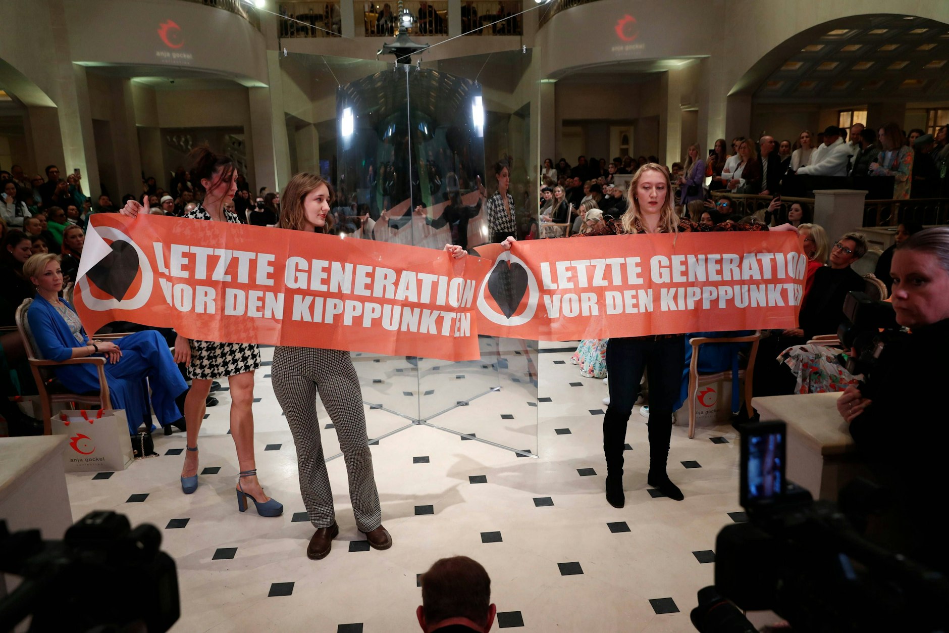 Zwei Frauen blockieren eine Modeschau im Rahmen der Berlin Fashion Week im Hotel Adlon Kempinski.