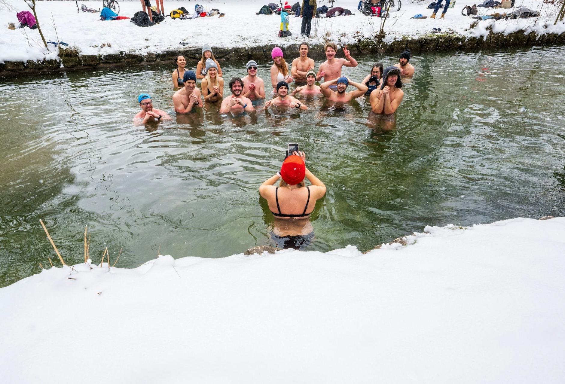 dpatopbilder - Mitglieder der Gruppe «Munich Hot Springs» baden bei eisigen Temparaturen und Schneefall in einem Nebenarm des Eisbachs im Englischen Garten in München.