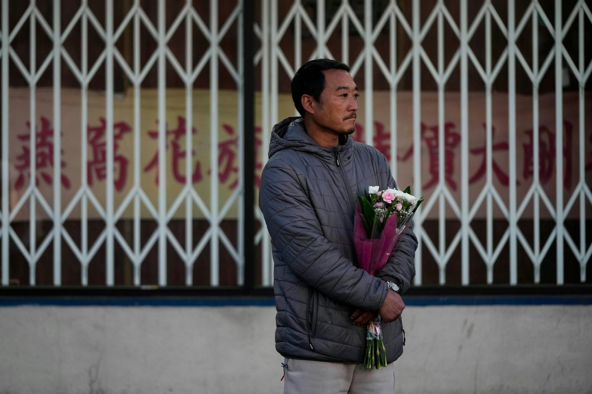 Hunter Zhao gedenkt mit Blumen der Opfer, die bei den Schüssen während der Neujahrsfeierlichkeiten in einem Tanzstudio in der überwiegend asiatisch-amerikanischen Gemeinde Monterey Park in Kalifornien getötet wurden.
