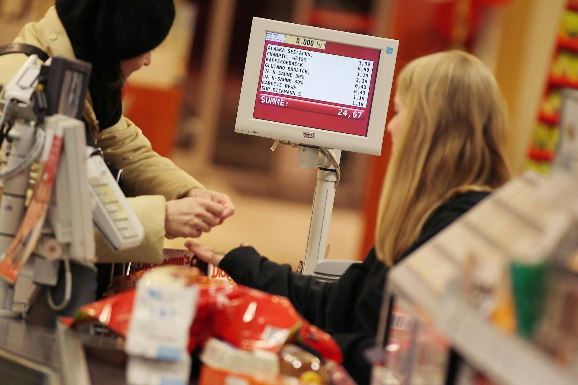 Eine Kassiererin nimmt in einem Rewe-Supermarkt das Geld einer Kundin entgegen. Noch zwei Jahre lassen sich dort auch Payback-Punkte sammeln.