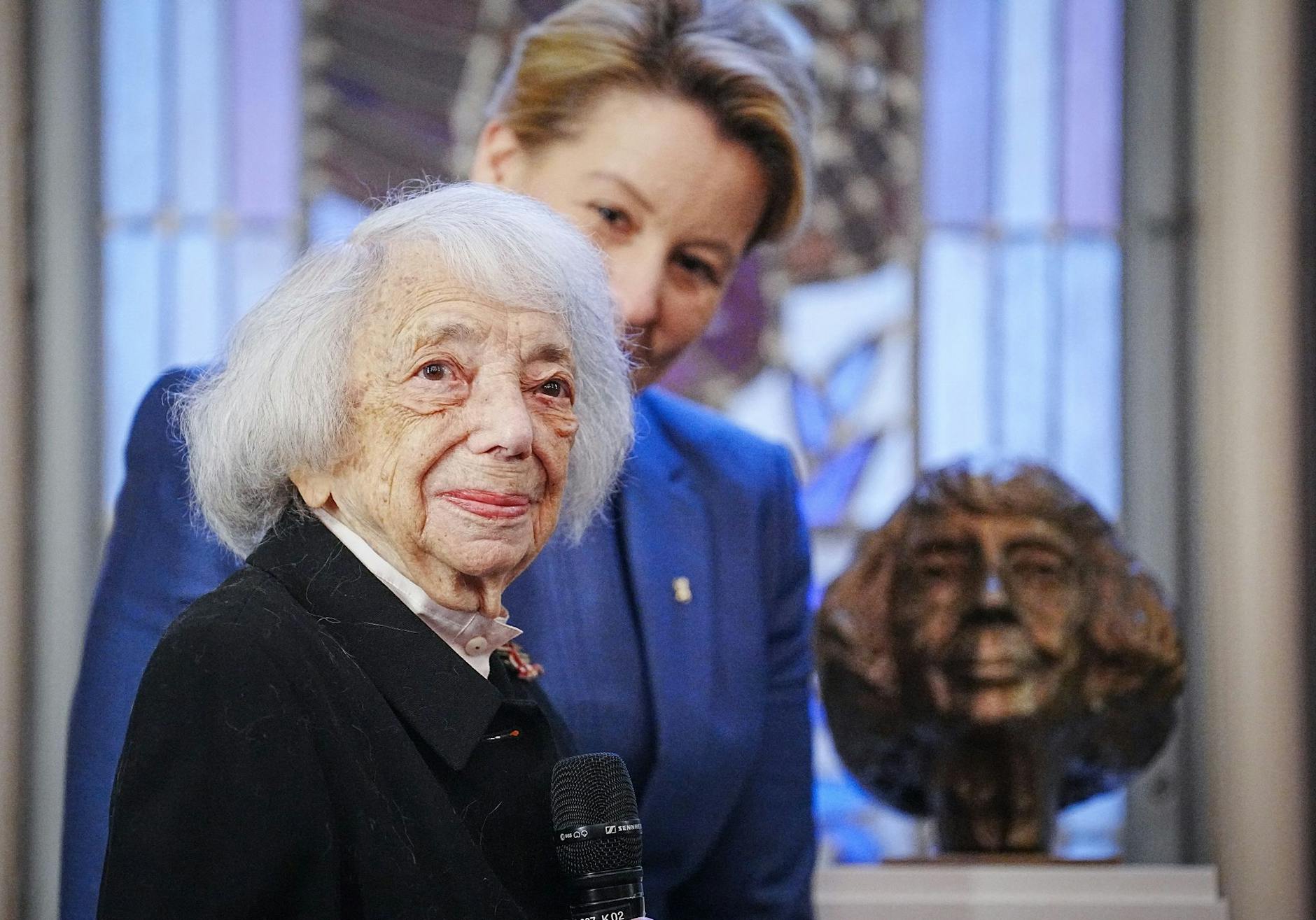 ARCHIV - Margot Friedländer, Holocaust-Überlebende, und Franziska Giffey (r, SPD), Regierende Bürgermeisterin von Berlin, steht nach der Verleihung des Bundesverdienstkreuzes 1. Klasse neben einer Büste, die Friedländer zeigt.
