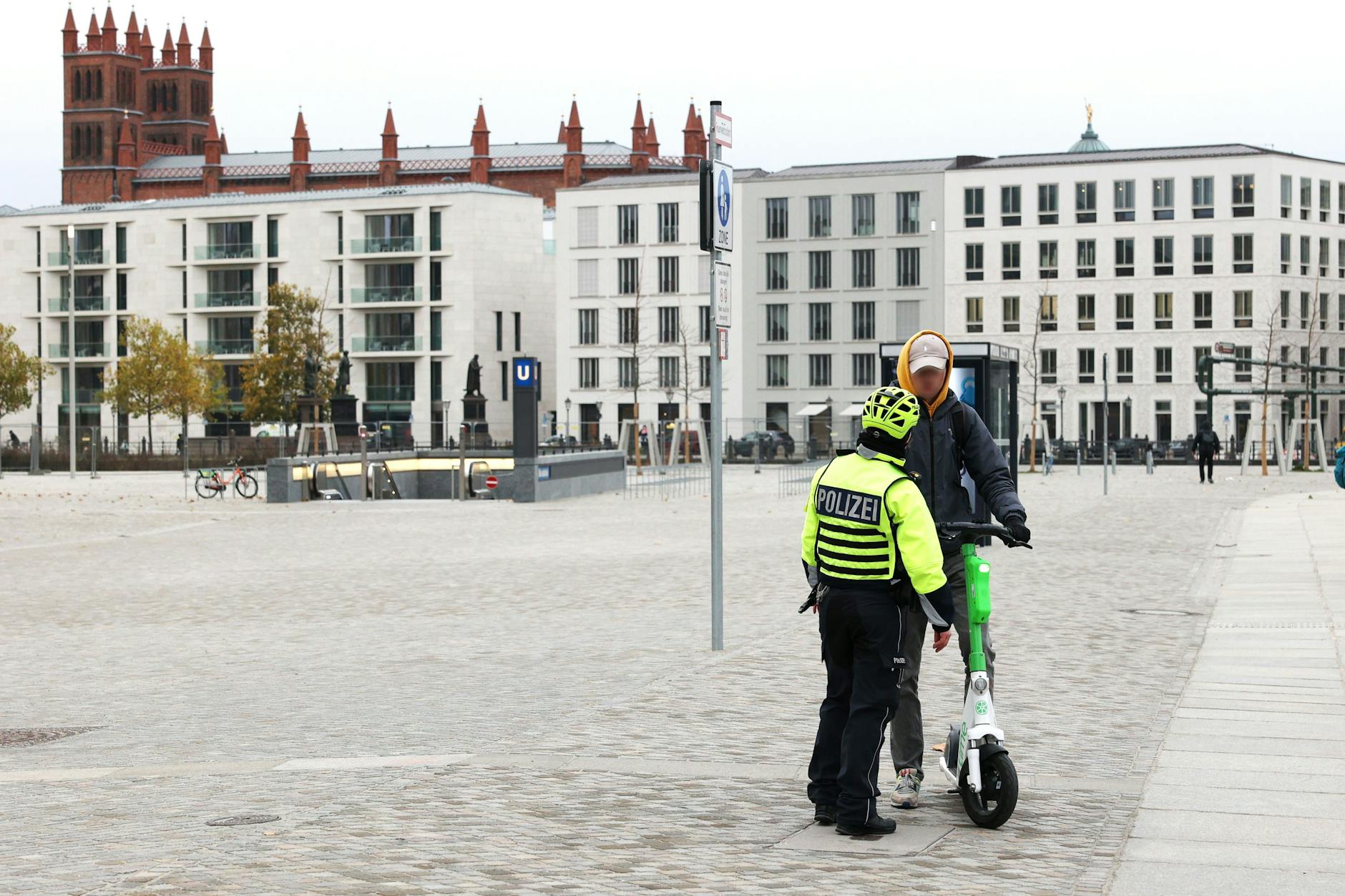 Na, was machen wir denn mit dem E-Roller auf dem Fußweg? Polizeilicher Anraunzer am Humboldt-Forum.