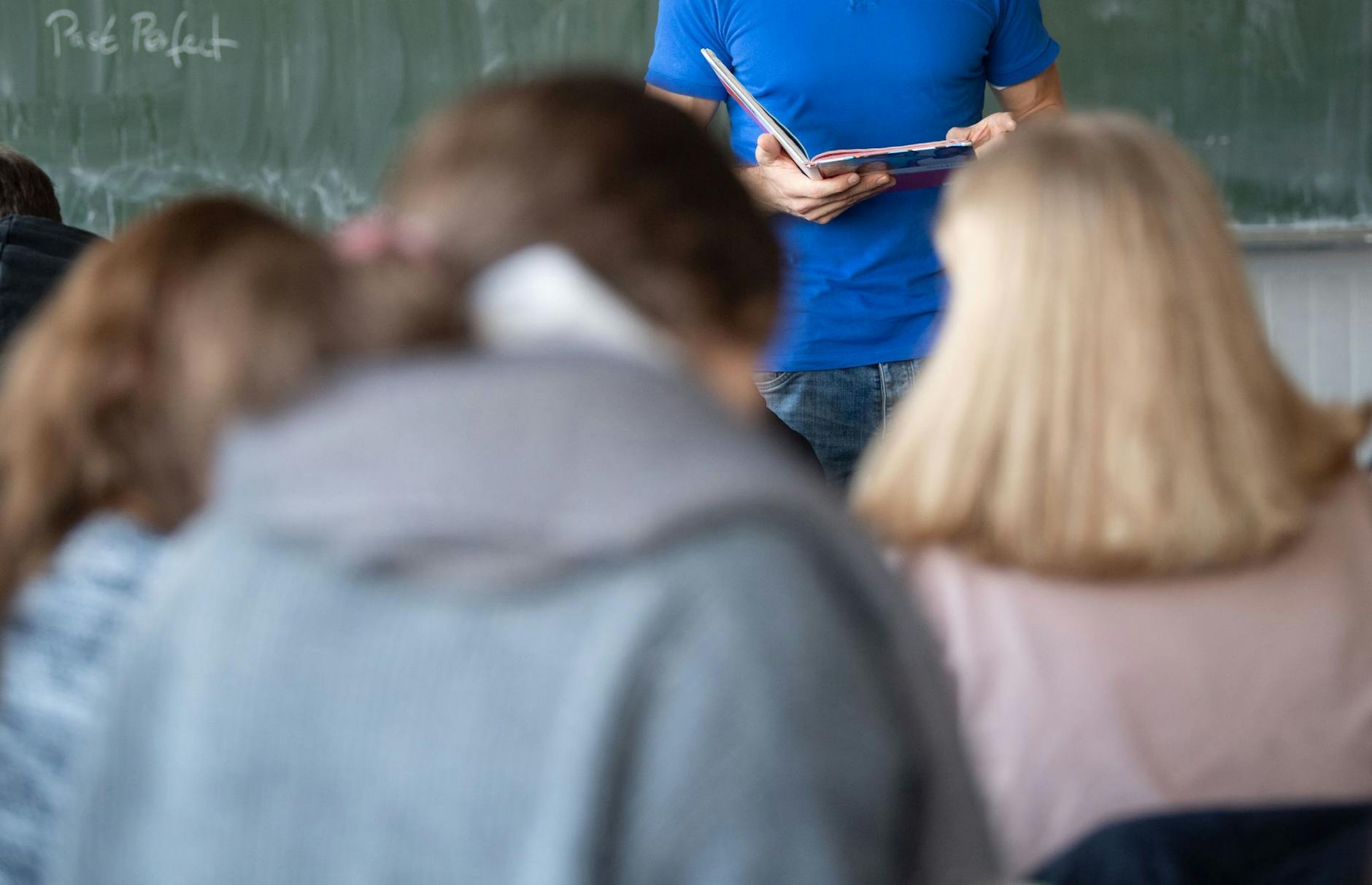 ARCHIV - Ein Lehrer steht im Unterricht an der Tafel.