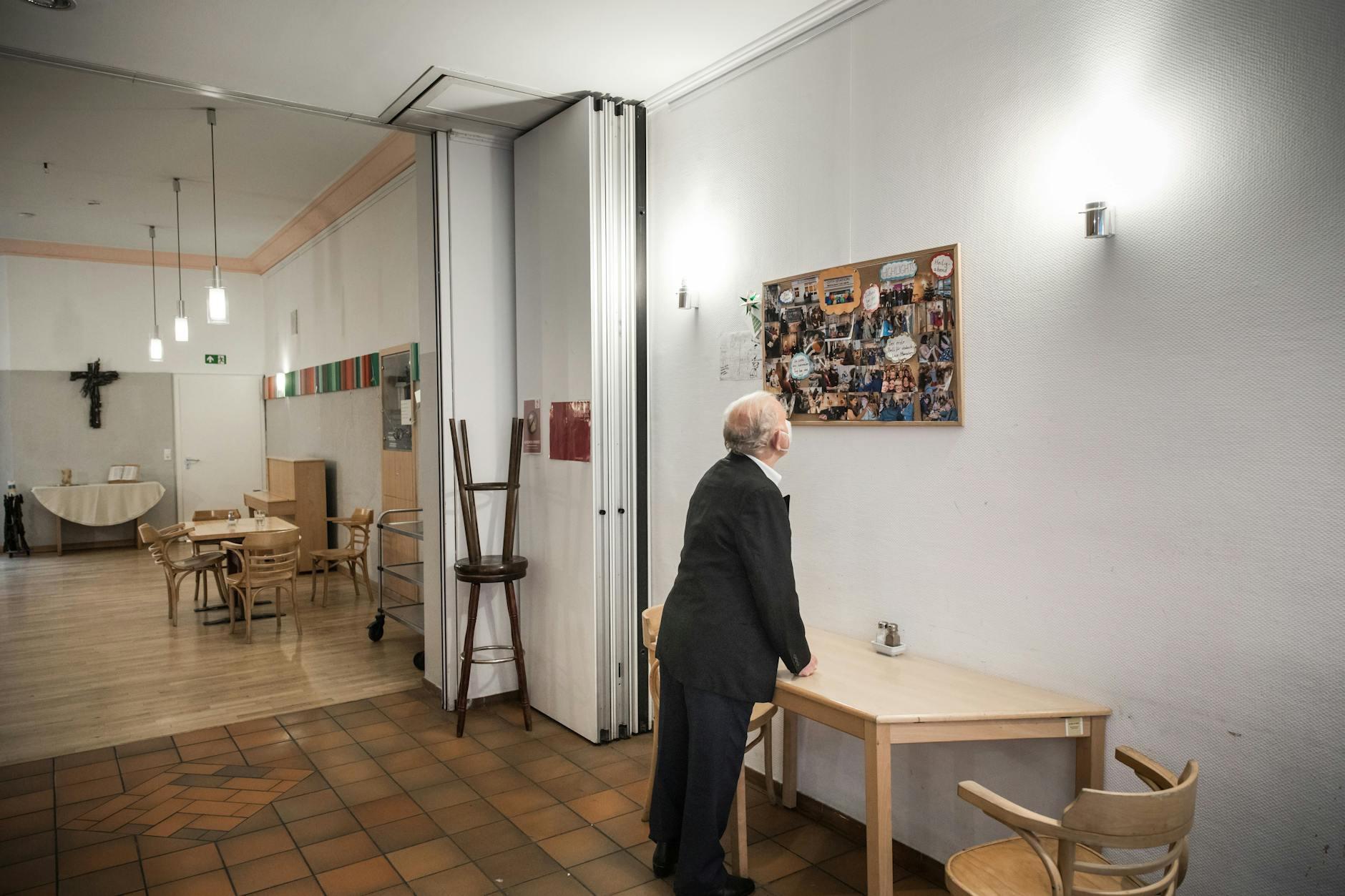 Ein Gast betrachtet einen Aushang mit Fotos von Festen und Ausflügen der City-Station.