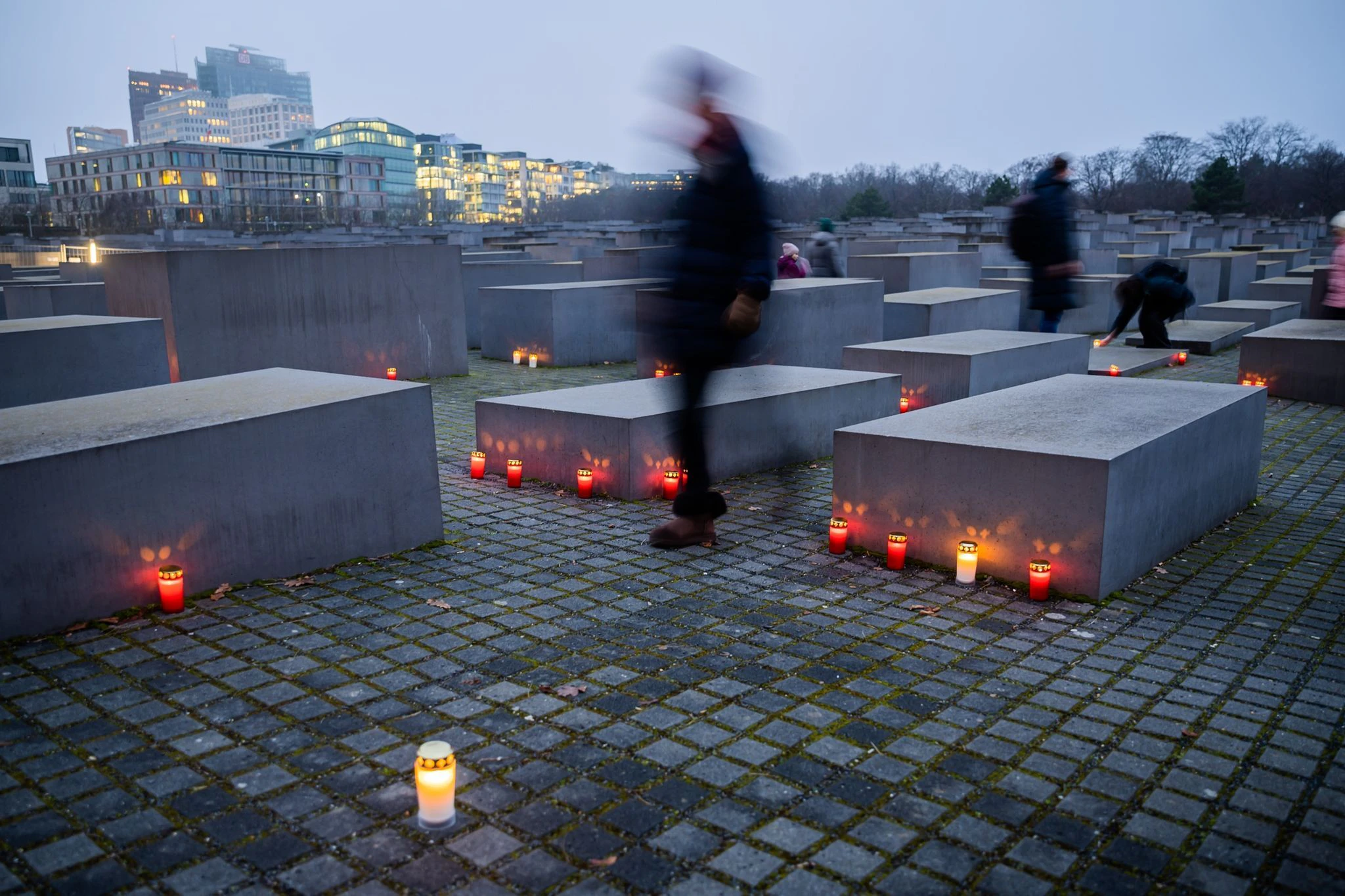 Kerzen brennen am Vorabend des Internationalen Tags des Gedenkens an die Opfer des Holocaust zwischen den Stelen des Denkmals für die ermordeten Juden Europas in Berlin.  