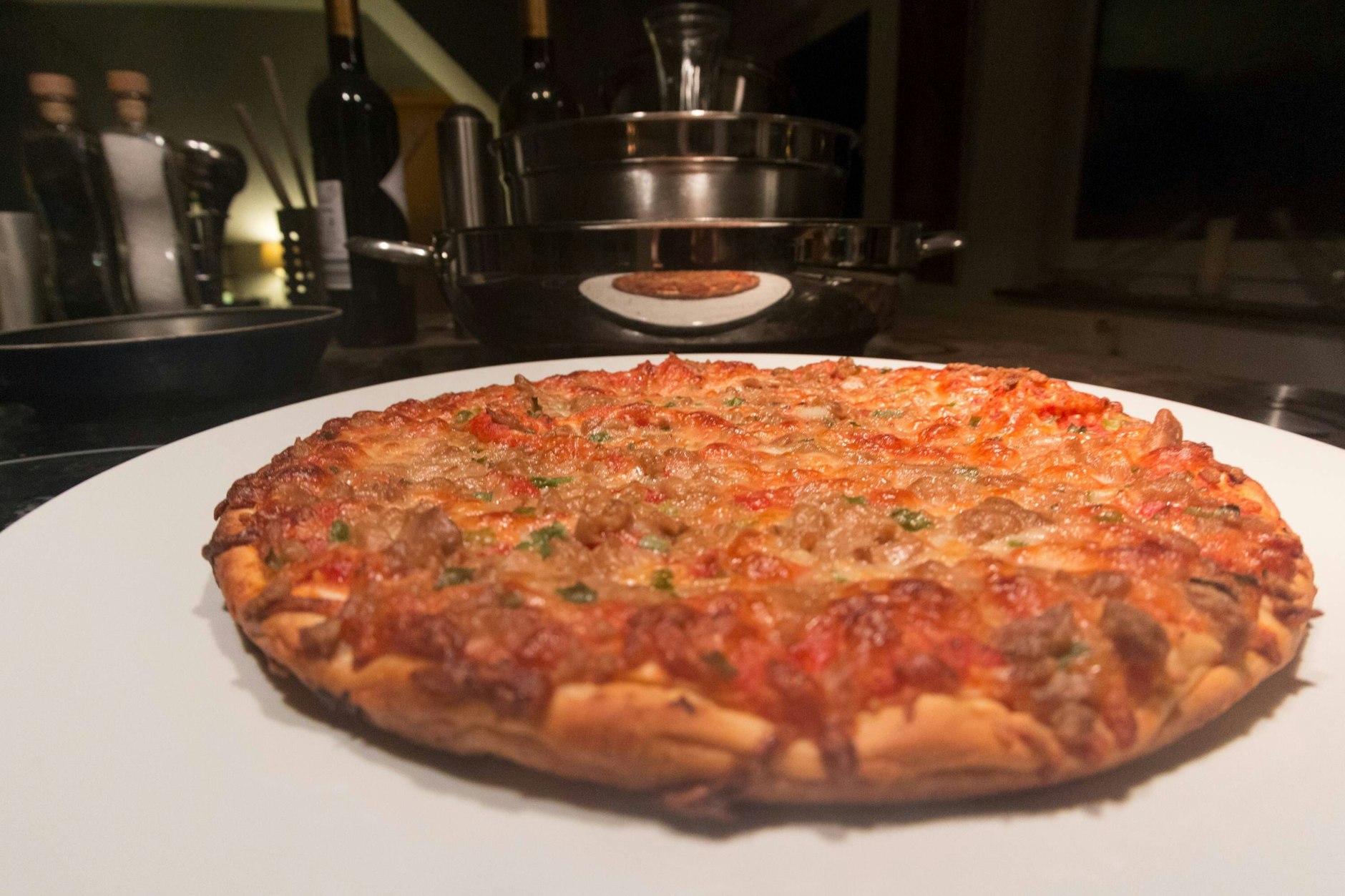 Eine gebackene Tiefkühlpizza, belegt mit Tunfisch, auf einem Pizzateller