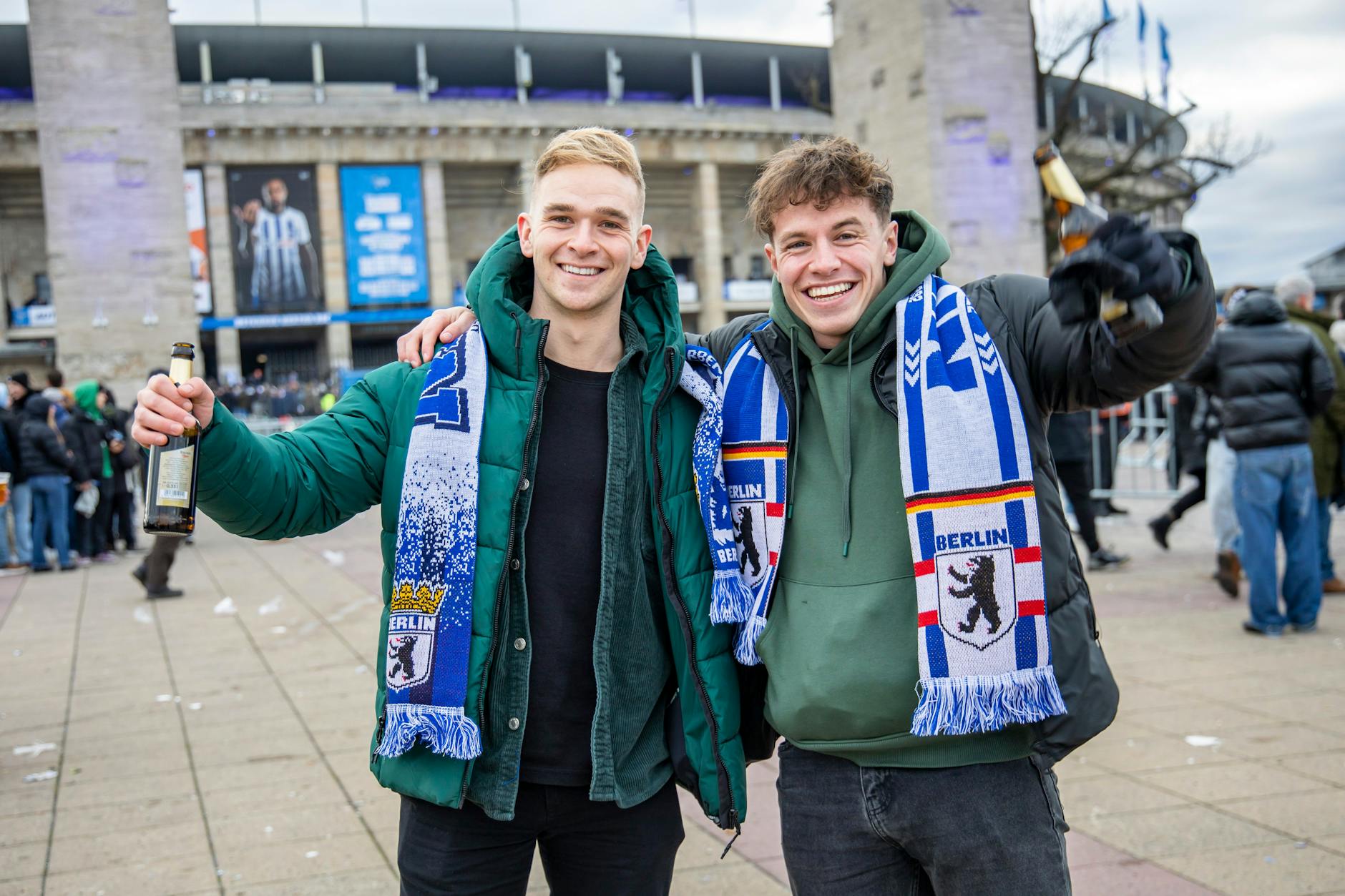 Hertha-Fans Patrick (l.) und Finbarr (r.) posieren vor dem Olympiastadion vor dem Bundesliga-Derby Hertha BSC gegen Union FC in Berlin. Sie sind extra für das Spiel aus Irland angereist.