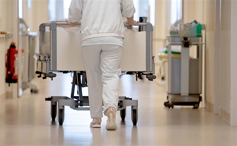 ARCHIV - Eine Krankenpflegerin schiebt ein Krankenbett durch einen Flur. Krankenhäuser gehören zu den Bereichen, in denen sich der Fachkräftemangel laut Studie weiter verschärfen wird.  