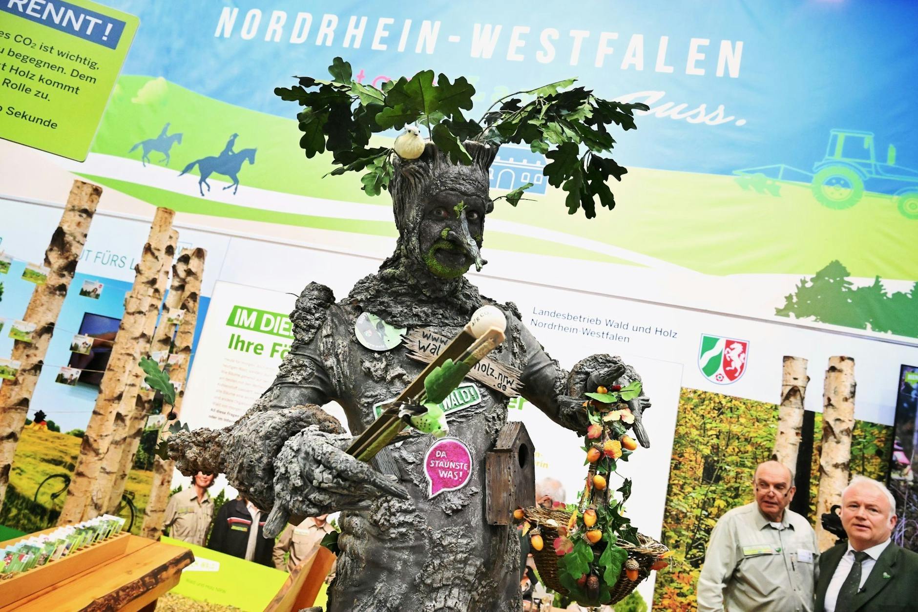 Ein als knorriger Baum verkleideter Mann sorgt bei der Internationalen Grünen Woche in der Messehalle für Aufsehen. 