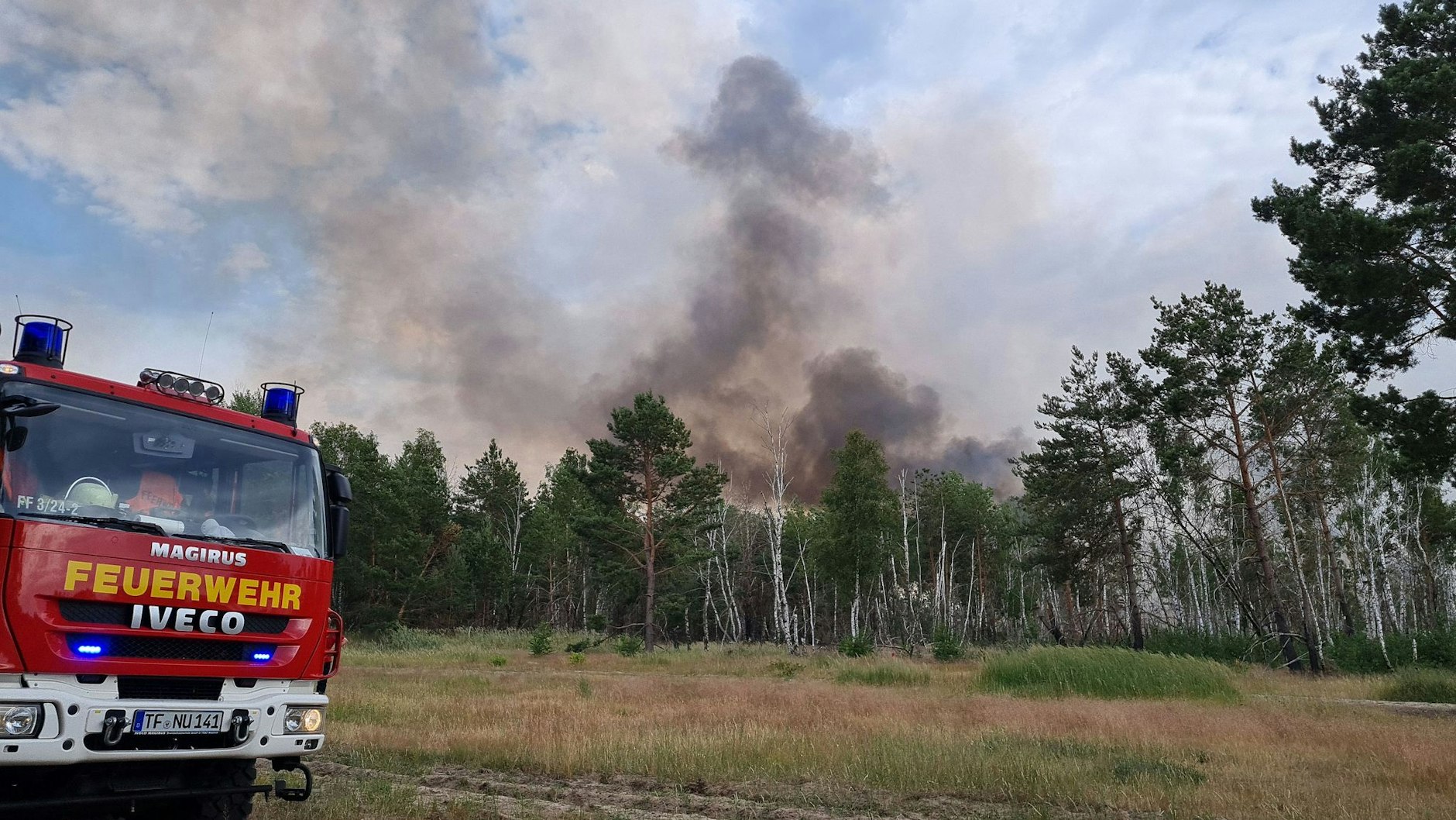 Ein Einsatzfahrzeug der&nbsp;Feuerwehr stehtim Sommer 2022&nbsp; in der Nähe des brennenden Waldstücks bei Jüterbog. Foto: Julian Stähle/dpa-Zentralbild/dpa