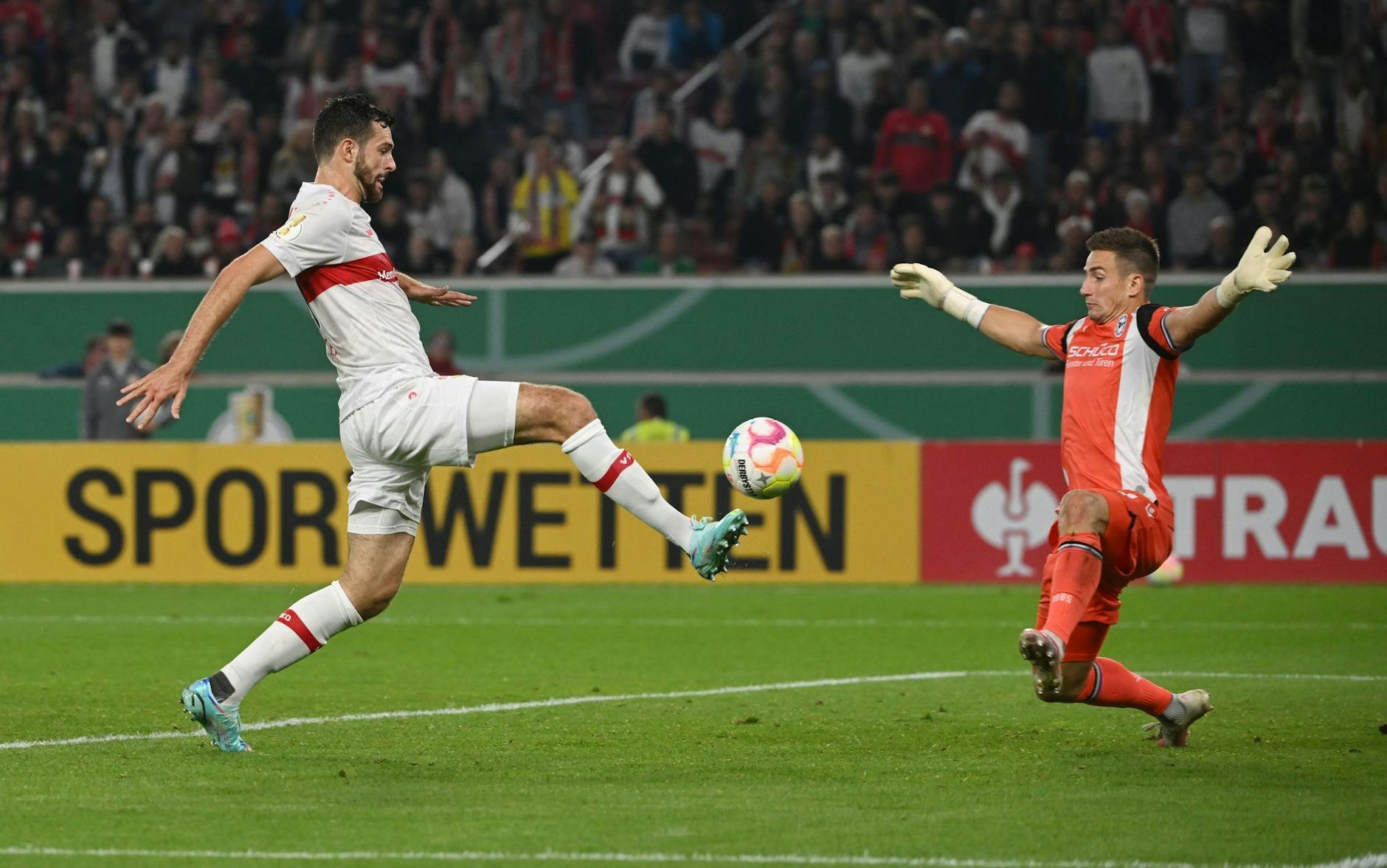Stuttgarts Luca Pfeiffer (l) schießt gegen Bielefelds Torwart Martin Fraisl das Tor zum 3:0. - Nutzung nur nach schriftlicher Vereinbarung mit der dpa