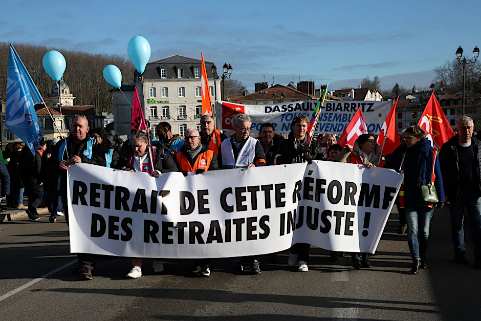Demonstranten halten ein Transparent mit der Aufschrift „Rücknahme der ungerechten Rentenreform“ während eines Protestmarsches in Bayonne.