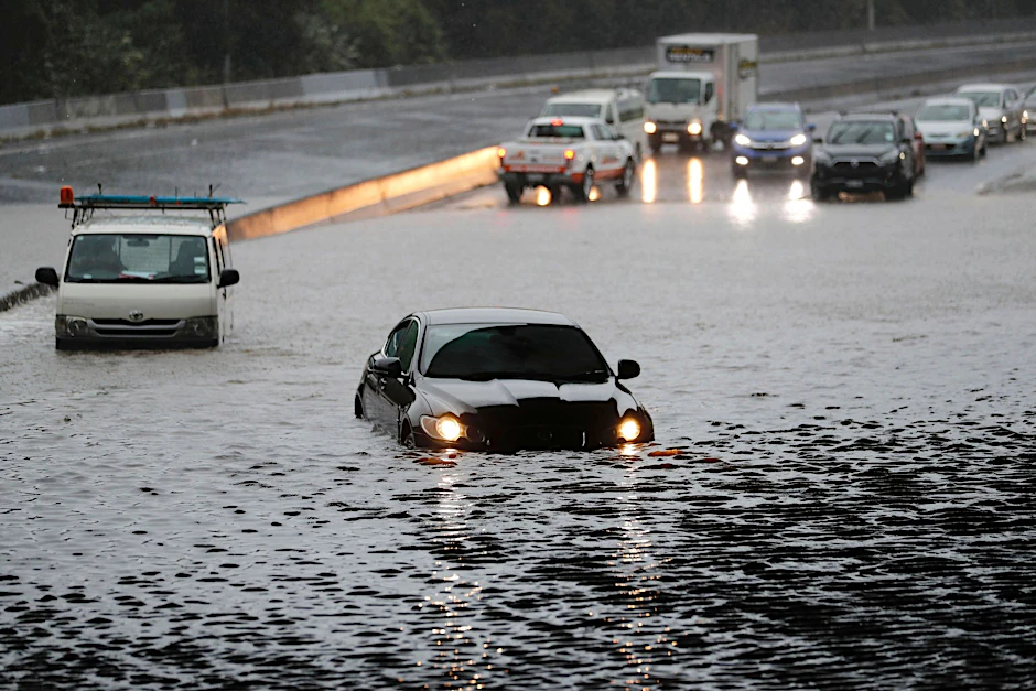 dpatopbilder - Fahrzeuge im Hochwasser auf einer überschwemmten Straße in Auckland.  dpa
