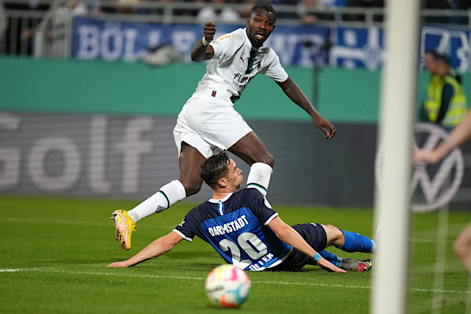 Gegenspieler im Pokal-Duell: Darmstadts Jannik Müller und Gladbach-Profi Marcus Thuram.   - Nutzung nur nach schriftlicher Vereinbarung mit der dpa