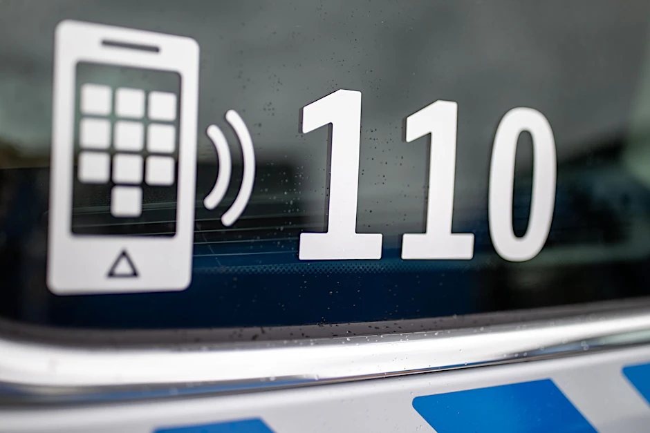 ARCHIV - Der Nummer des Polizeinotrufs 110 steht auf der Scheibe eines Polizeifahrzeugs.  