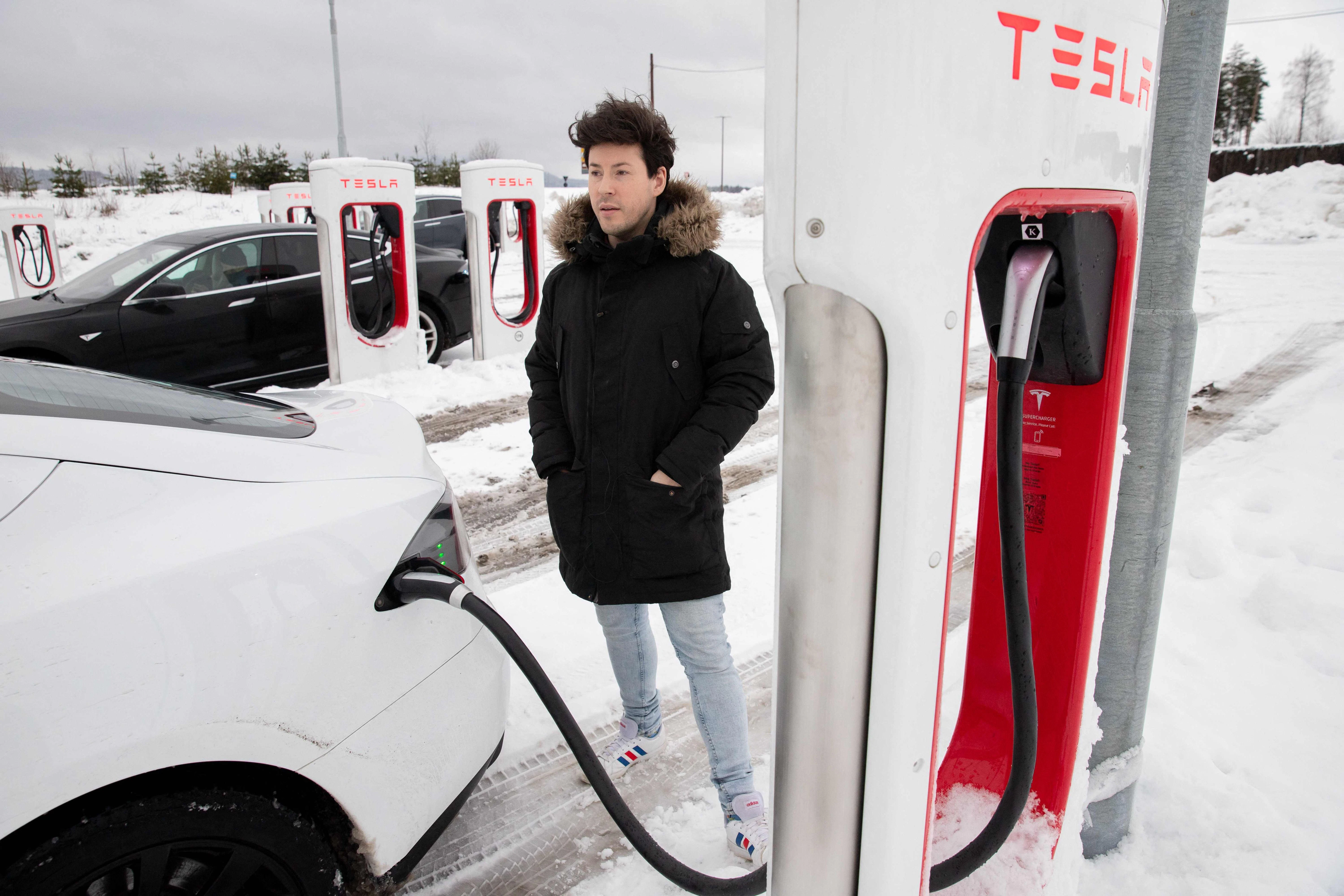 Ein Teslabesitzer an einer Ladestation.