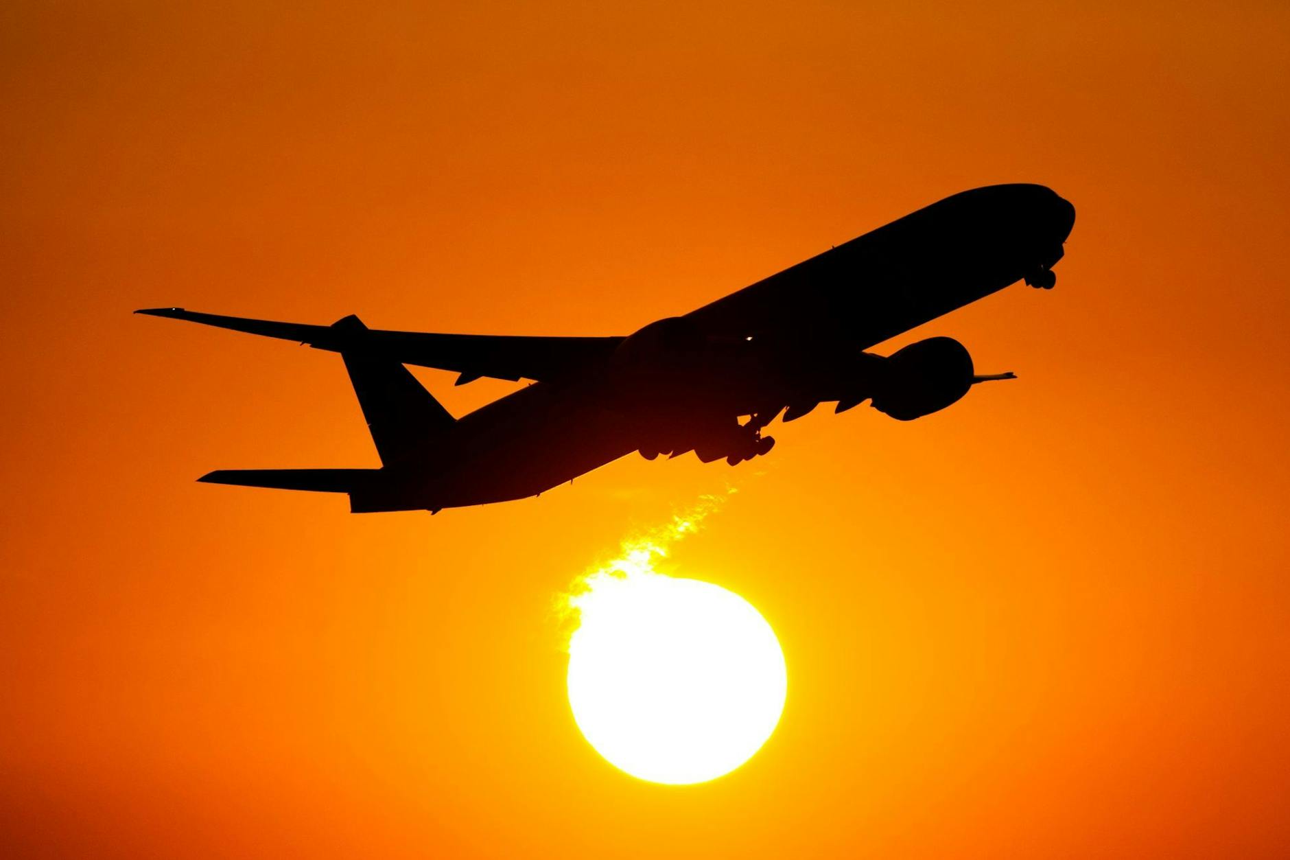 Eine Boeing 777 startet bei Sonnenuntergang vom Flughafen Frankfurt/Main.