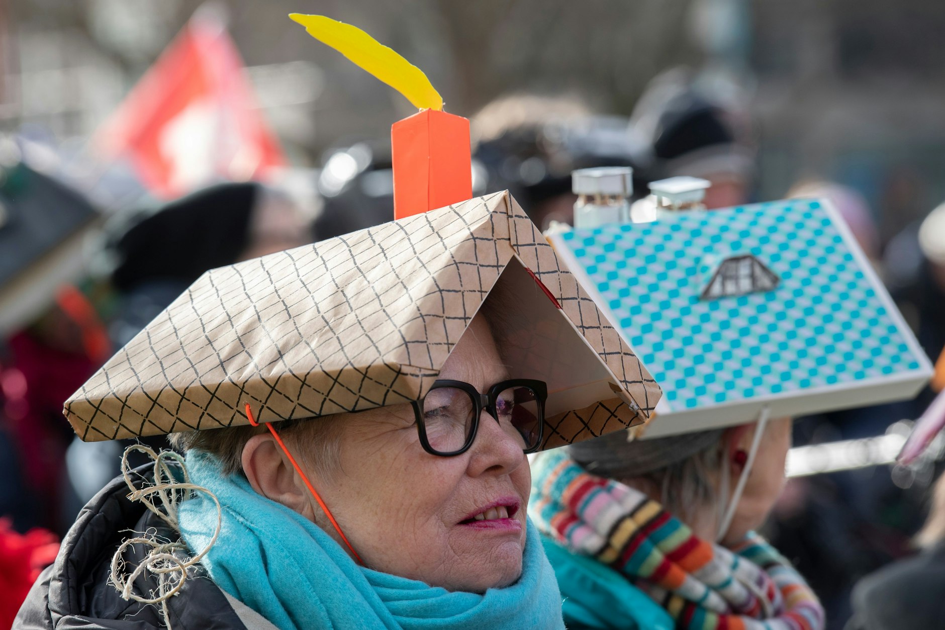 Frauen tragen bei der Demonstration gegen die Berliner Wohnungspolitik Modelle von Hausdächern auf ihren Köpfen.