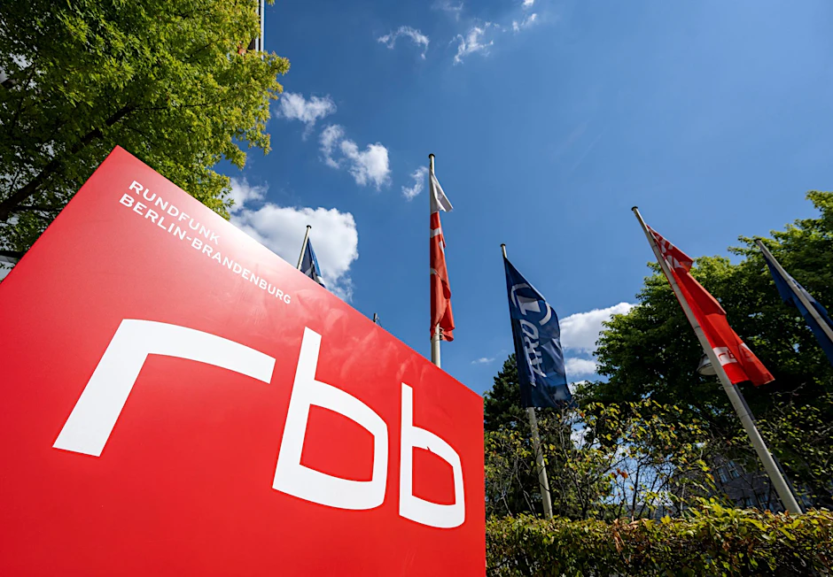 ARCHIV - Ein Schild mit dem Logo des öffentlichen Senders Rundfunk Berlin-Brandenburg (RBB) vor dem Eingang zum Sitz des Senders an der Masurenallee.  