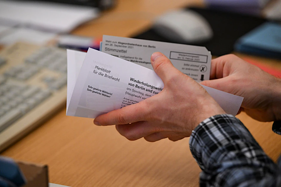Mitarbeiter bereiten Wahlunterlagen für die Briefwahl vor.