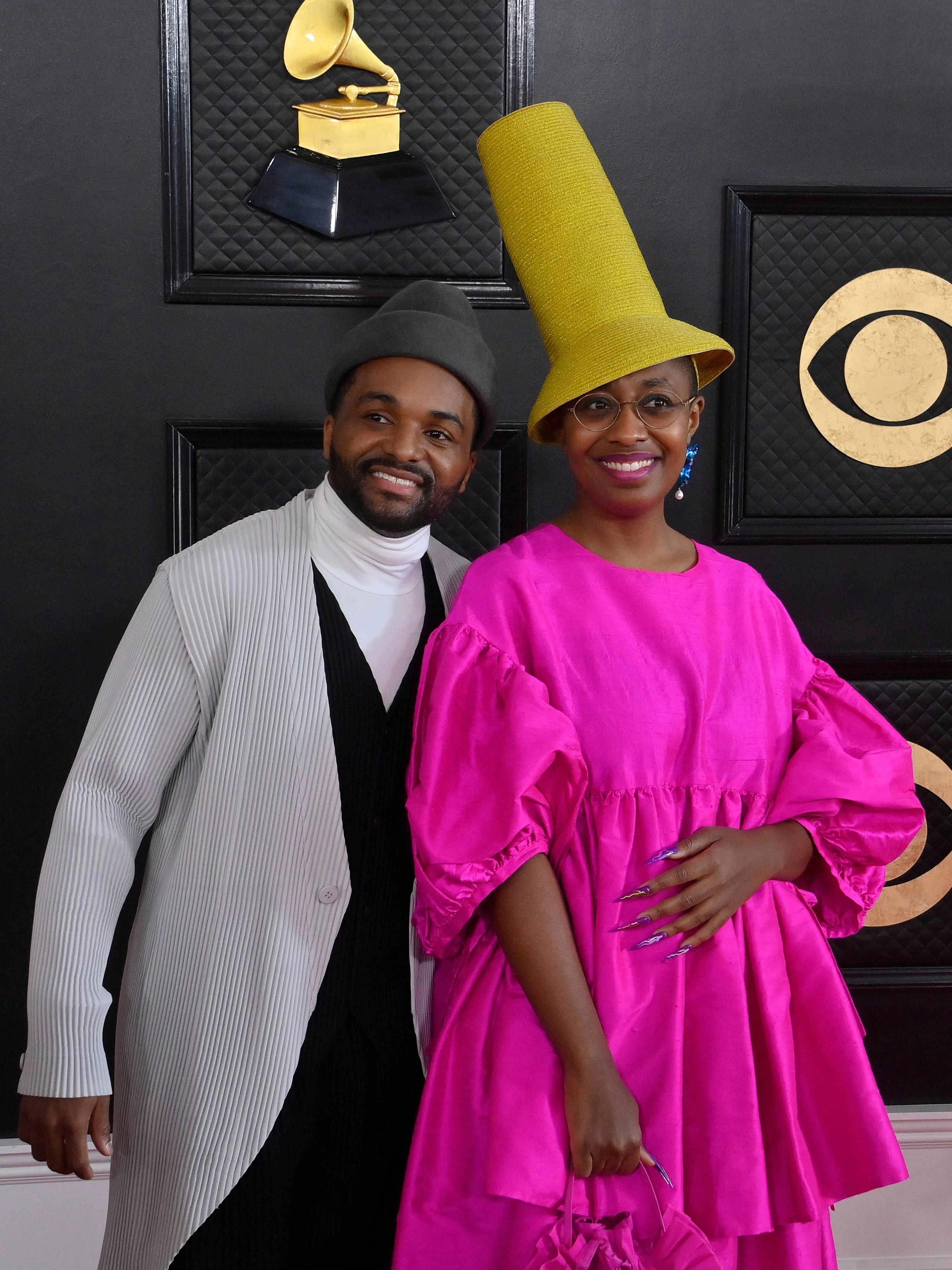 <strong>TOP:</strong> Zusammengenommen machen Sullivan Fortner und Cécile McLorin eine überaus gute Figur. Aber auch für sich wissen beide zu überzeugen: Der Jazz-Musiker Fortner in einem – für den roten Teppich zugegebenermaßen etwas arg lässigen – plissierten Mantel; McLorin, die ebenso im Jazz-Bereich unterwegs ist, mit einem exaltierten Hutmodell zum großzügig geschnittenen pinkfarbenem Kleid. Damit beweist gerade Cécile McLorin: Man kann auch auffallen, ohne durchzufallen!