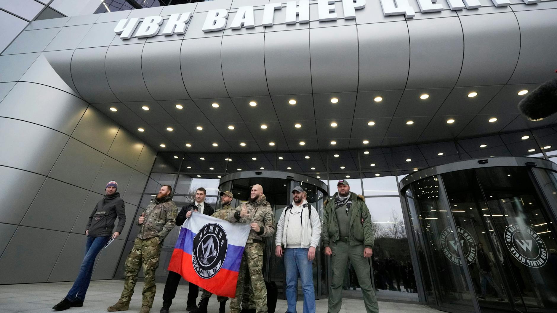 Männer posieren vor dem Firmensitz des Kriegsunternehmens Wagner in St. Petersburg