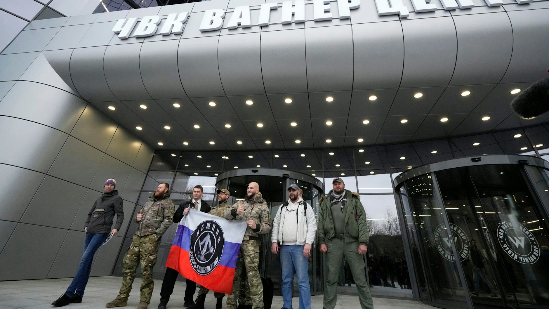 Männer posieren vor dem Firmensitz des Kriegsunternehmens Wagner in St. Petersburg