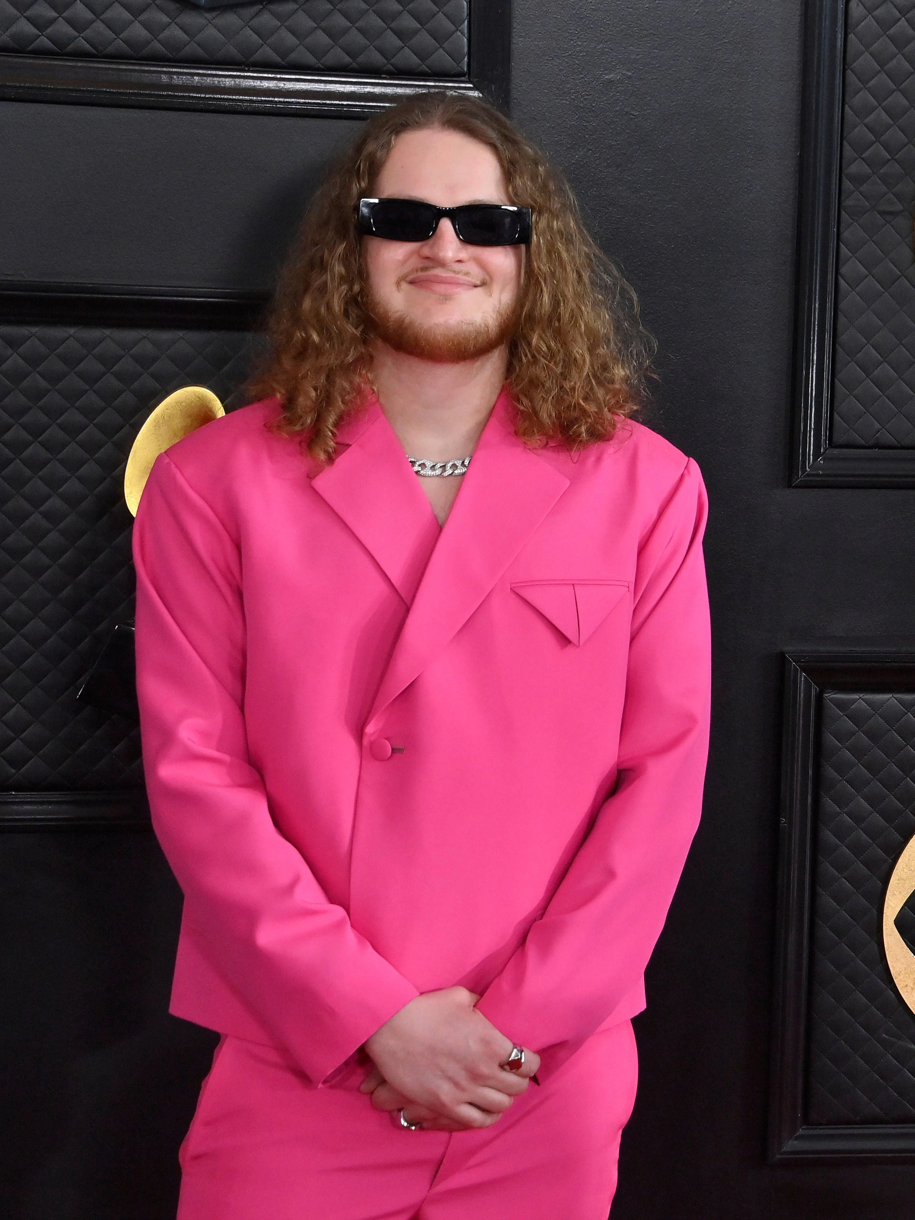 <strong>TOP:</strong> Es ist ein wirklich entzückender Pink-Ton, für den sich der noch recht unbekannte Musiker Solwas entschieden hat. Auch der boxy Schnitt seines maßgeschneiderten Jacketts steht ihm ausgezeichnet. Eine wirklich gute Sonnenbrille und eine dezente silberne Panzerkette kompletieren den Look bestens.