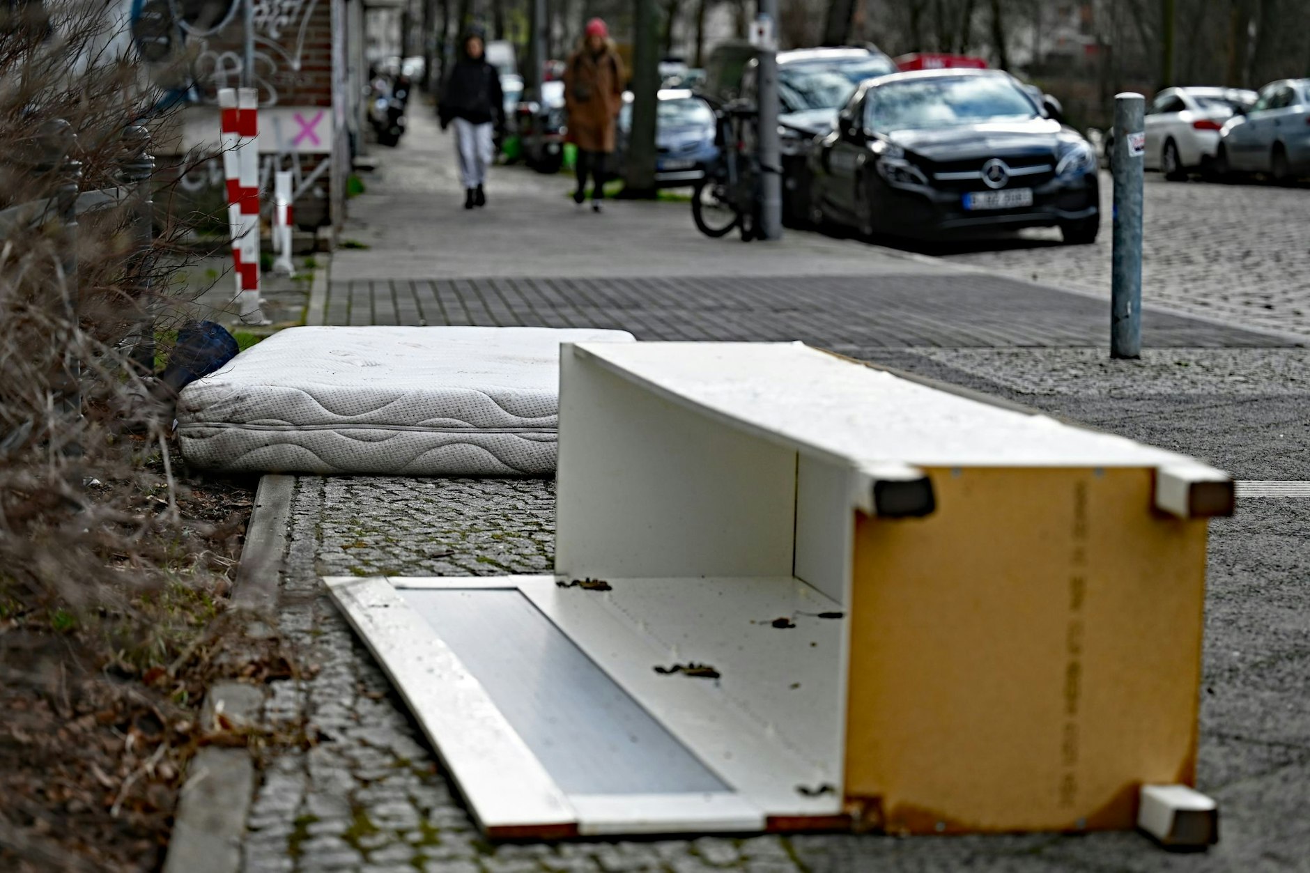 Eine ausrangierte Matratze und ein beschädigter Schrank liegen auf einem Gehweg. Berlin muss wegen Pannen nochmal wählen. Und mancher fragt sich: „Bekommen die eigentlich gar nichts hin?“