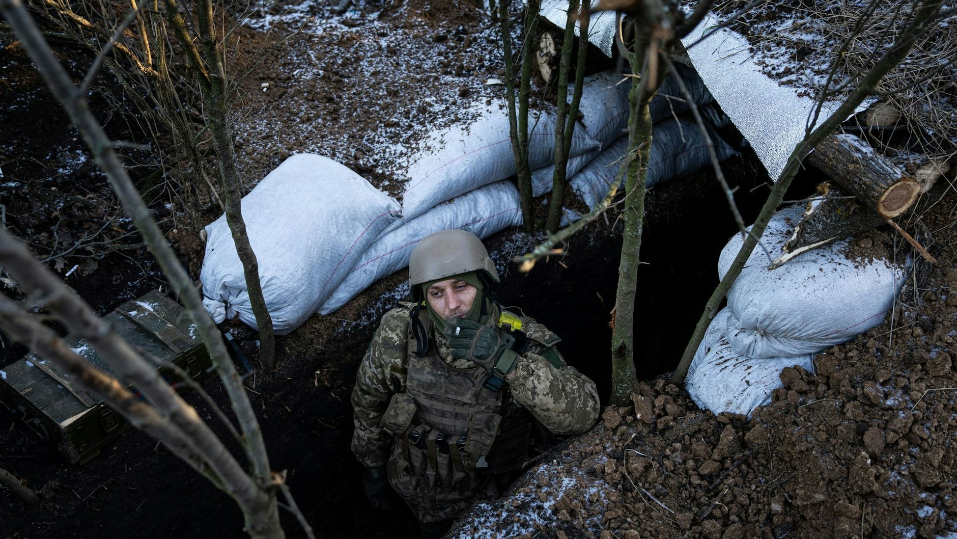 Ein ukrainischer Soldat raucht im Schützengraben bei Bachmut. Ein Bild wie aus dem Film „Im Westen nichts Neues“.