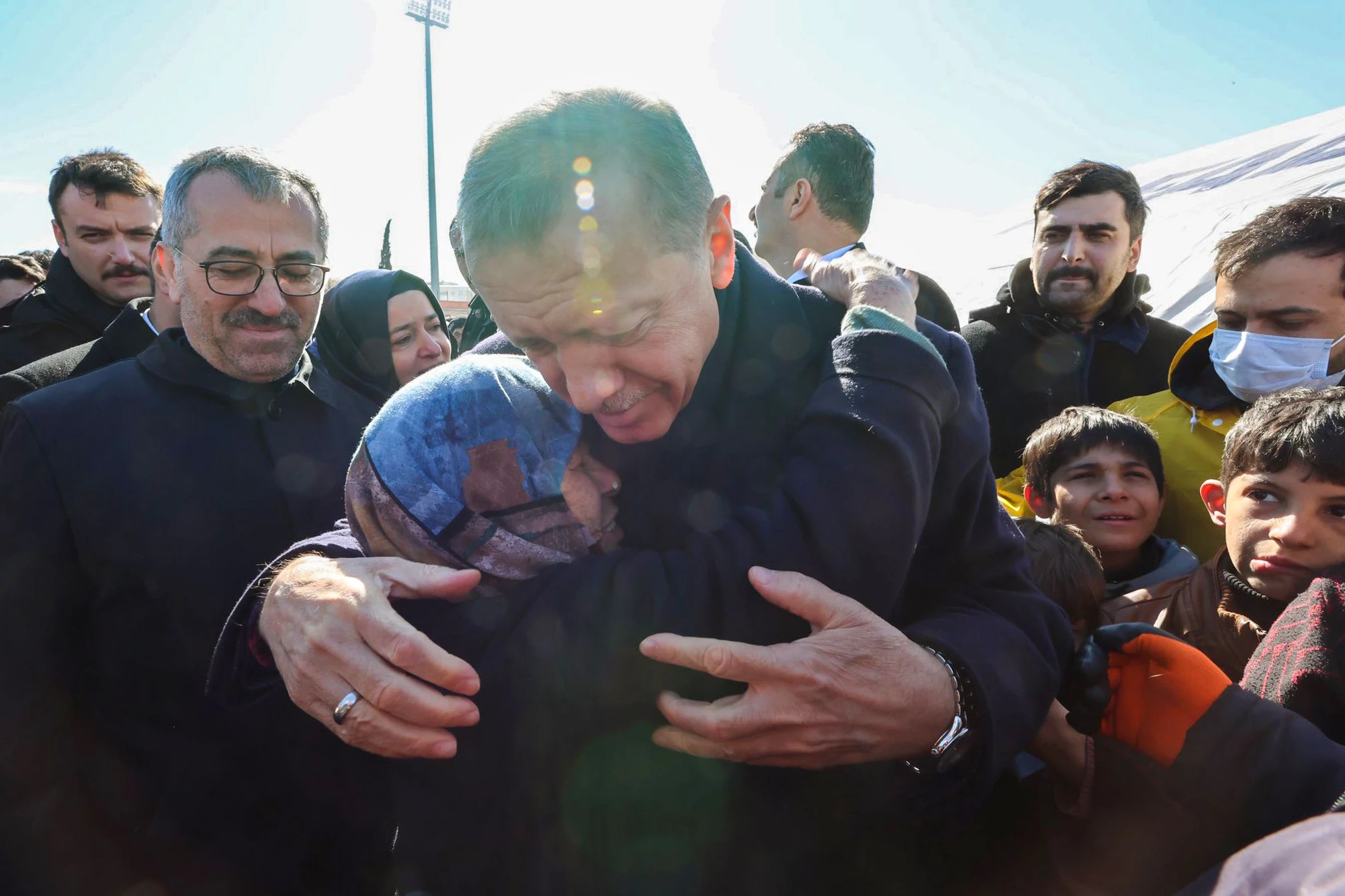 Recep Tayyip Erdogan umarmt eine Frau, als er ein Hilfslager für die Opfer der Erdbeben an der türkisch-syrischen Grenze besucht.