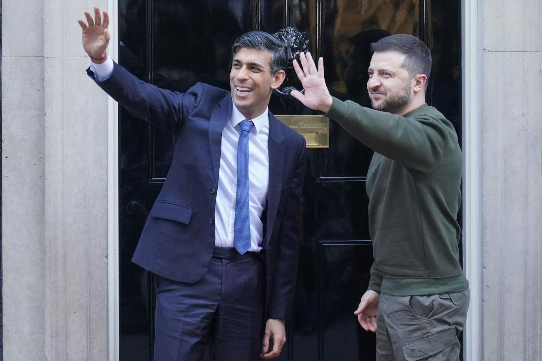 Der ukrainische Präsident Wolodymyr Selenskyj (r.) und Großbritanniens Premierminister Rishi Sunak stehen vor Beginn eines bilateralen Treffens vor der 10 Downing Street und winken.