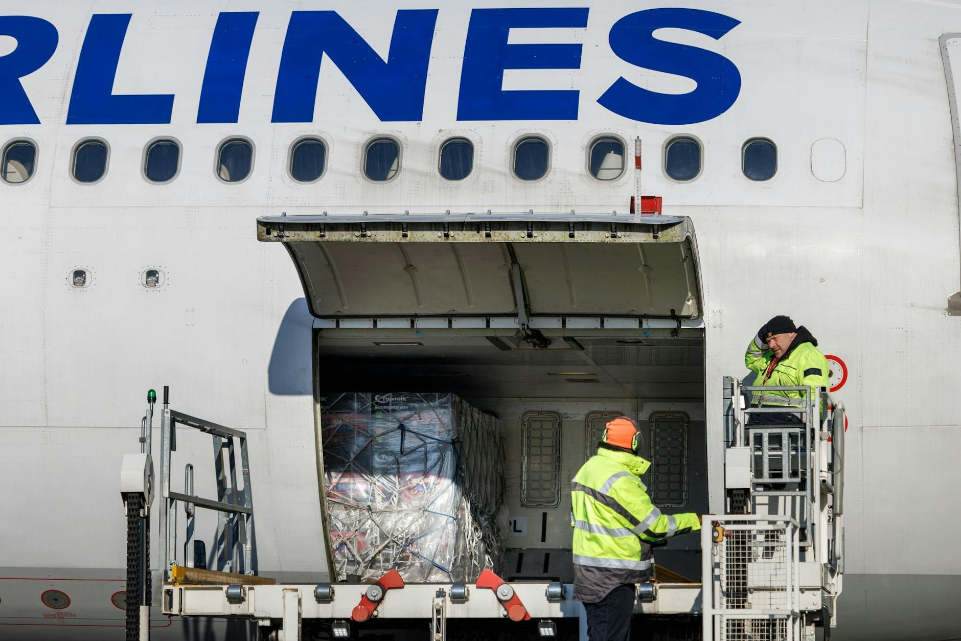 Flughafenmitarbeiter laden auf dem BER-Rollfeld Paletten mit Hilfsgütern für die Türkei in ein Flugzeug der türkischen Fluggesellschaft Türkish Airlines.